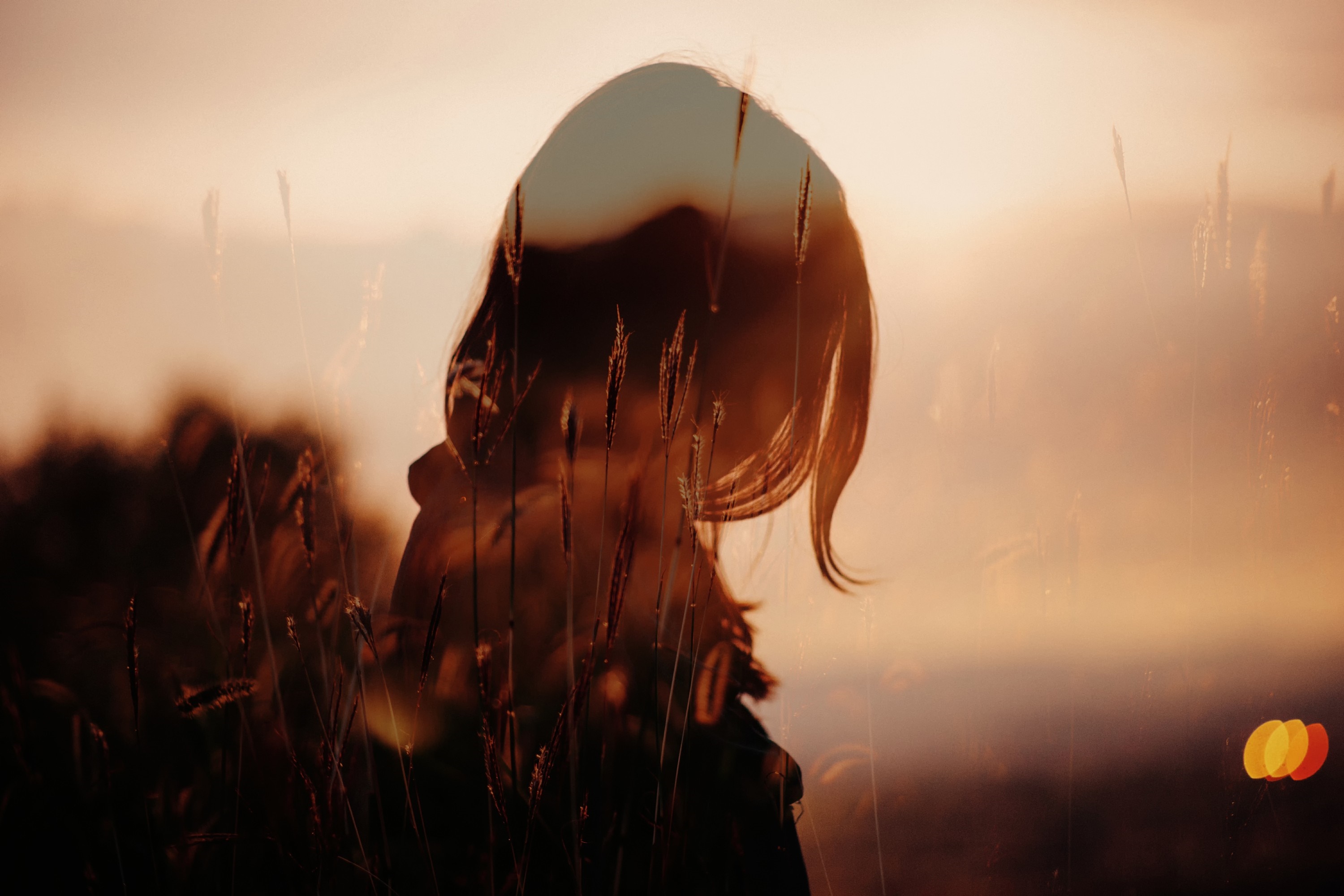Silhouette of a woman against a sunset with bokeh lights HD Wallpaper