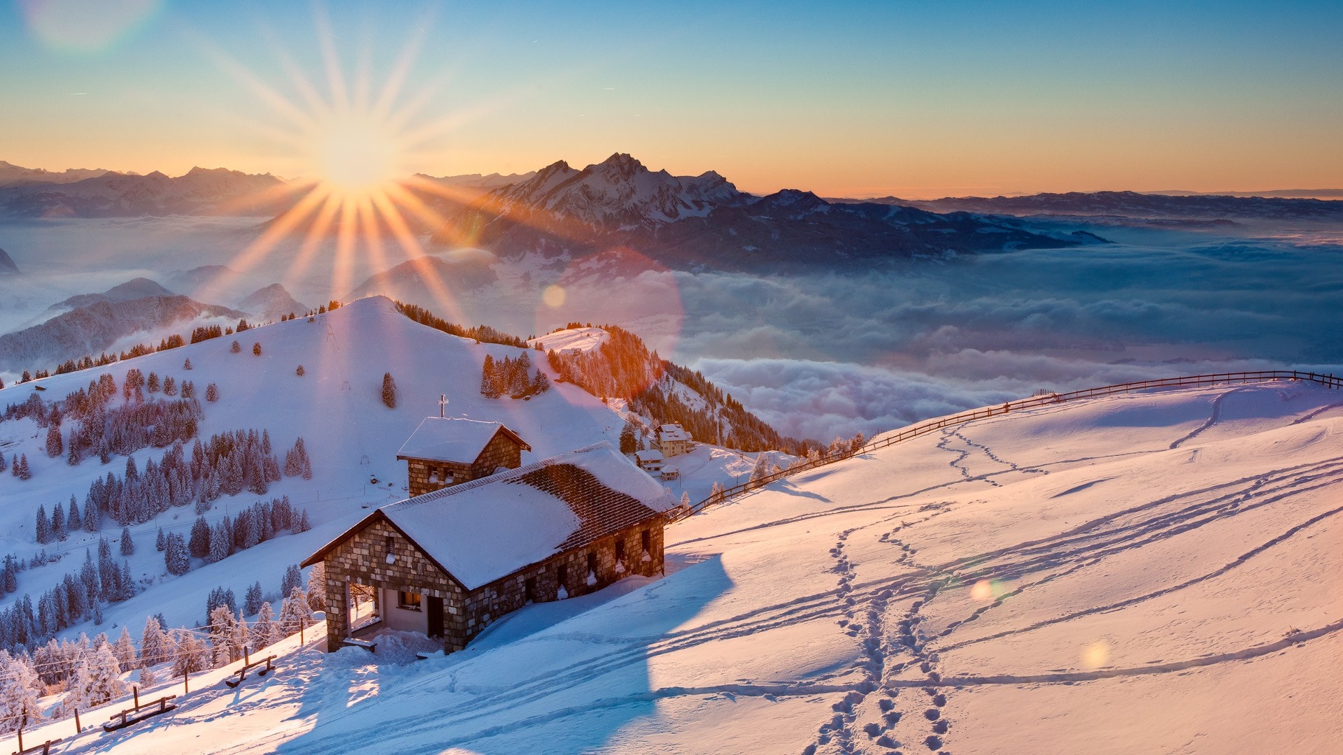 Sunrise over snowy mountains with cabins in Switzerland HD Wallpaper