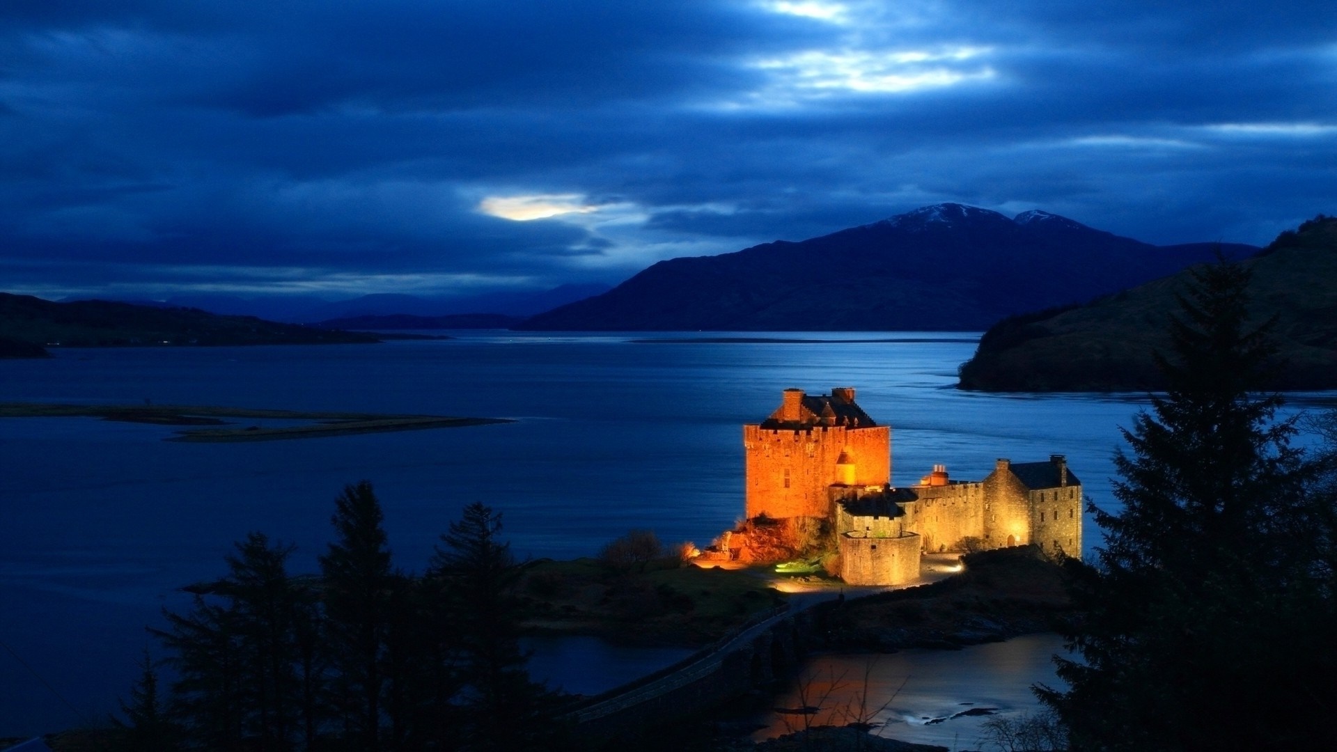 Eilean Donan Castle at night by a loch HD Wallpaper