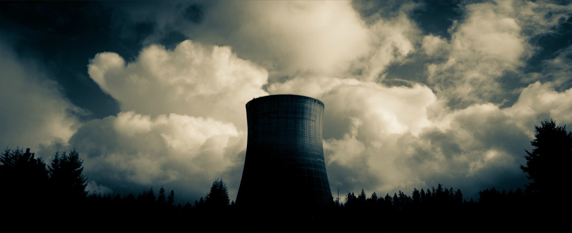 Cooling tower emitting steam against a cloudy sky HD Wallpaper