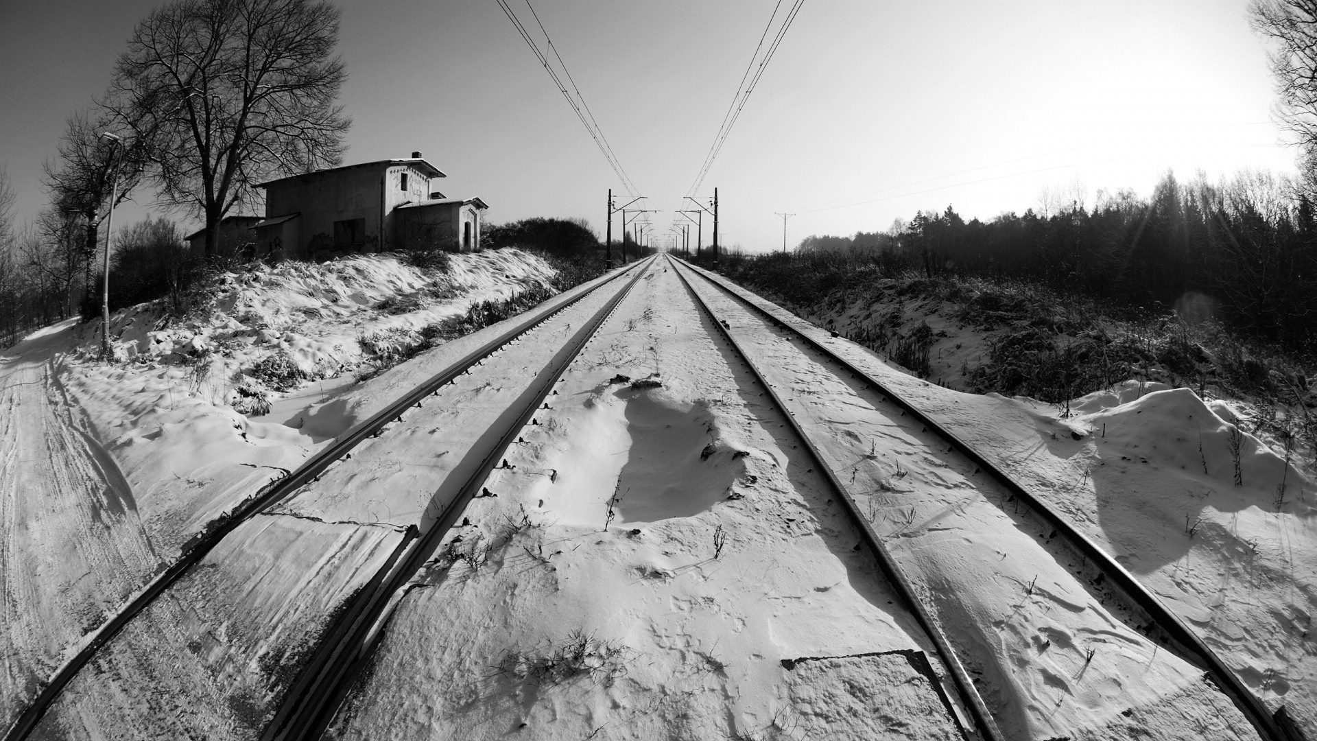 Snowy railway tracks with a building and trees HD Wallpaper