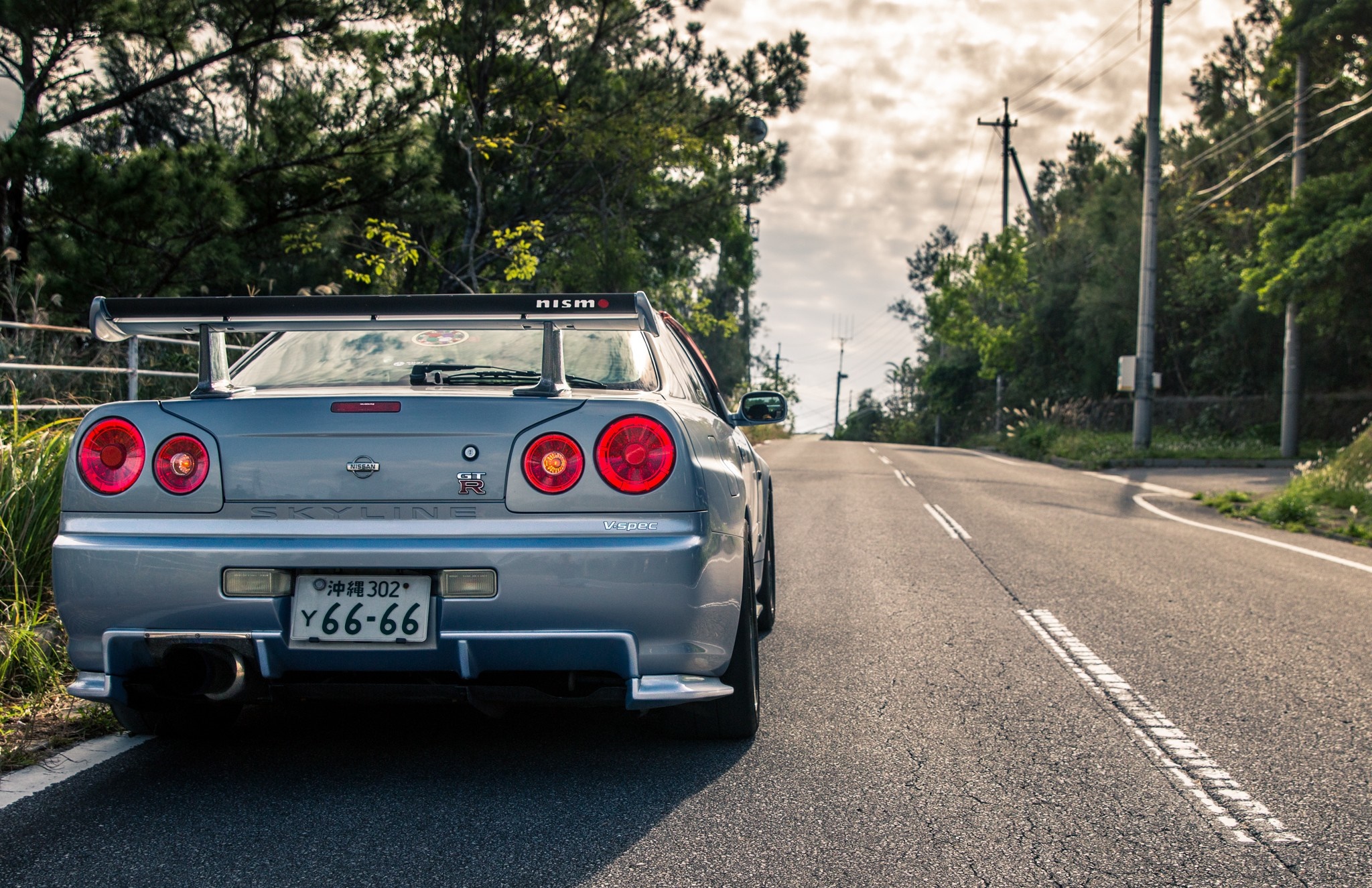 Nissan Skyline GT-R R34 parked on a road HD Wallpaper
