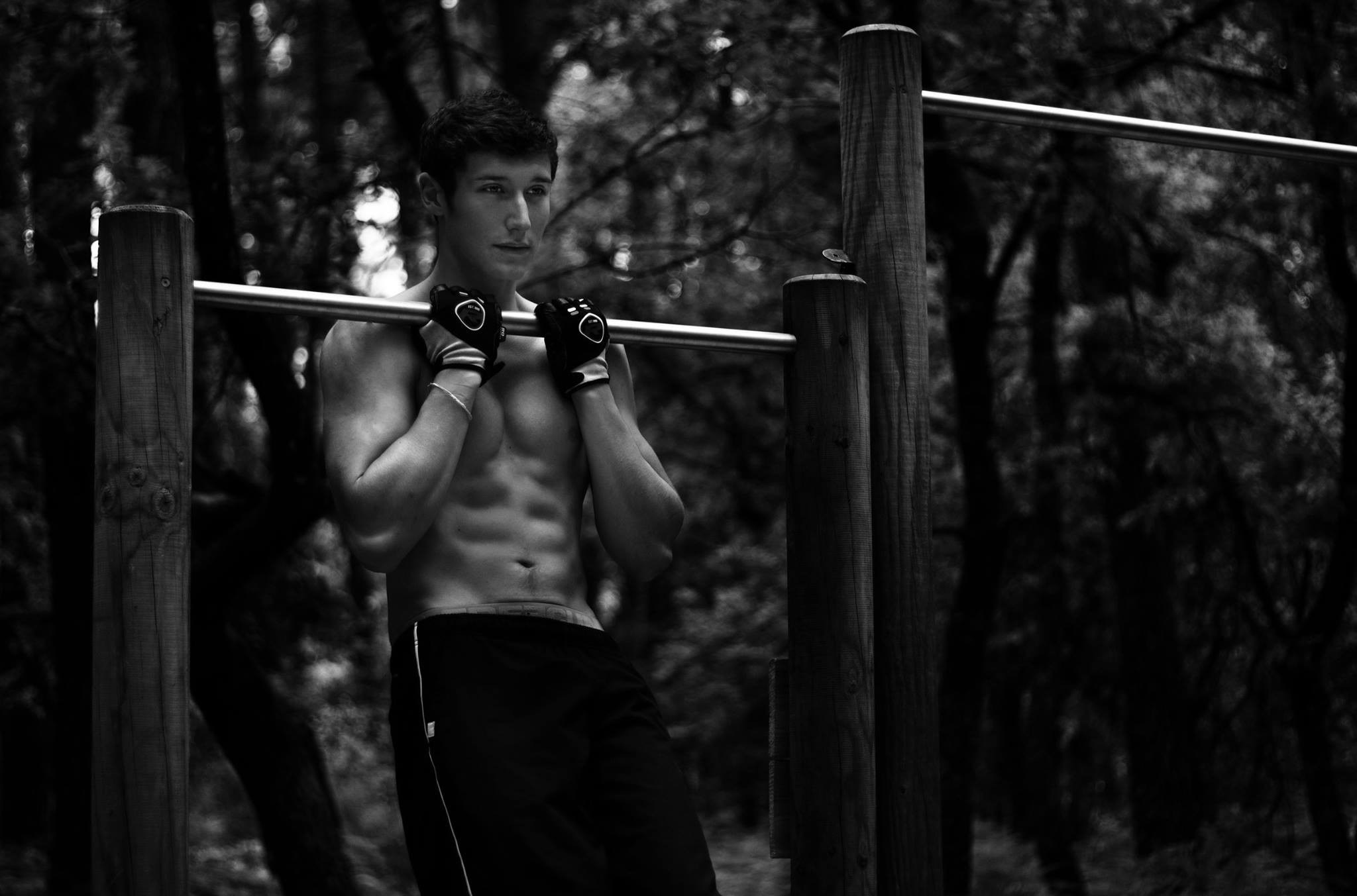 Man doing pull-ups on a bar in a forest HD Wallpaper