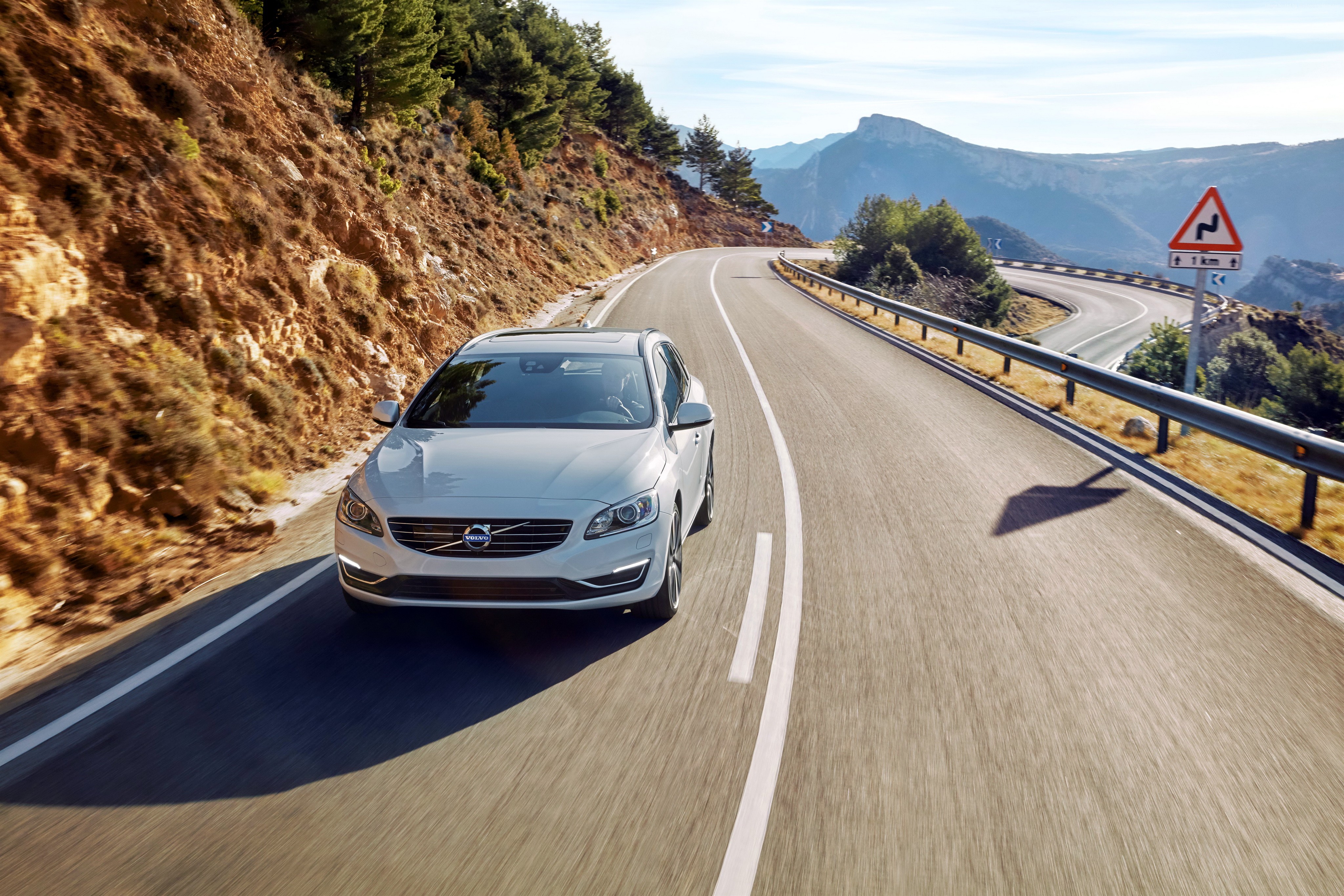 White Volvo V60 driving on a winding mountain road HD Wallpaper