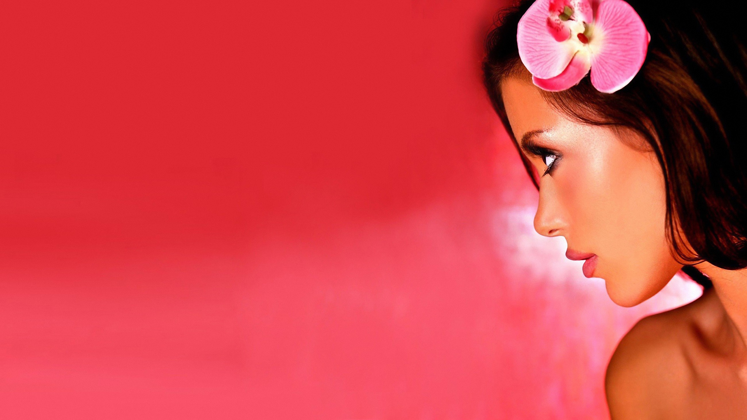Woman with pink orchid in her hair HD Wallpaper