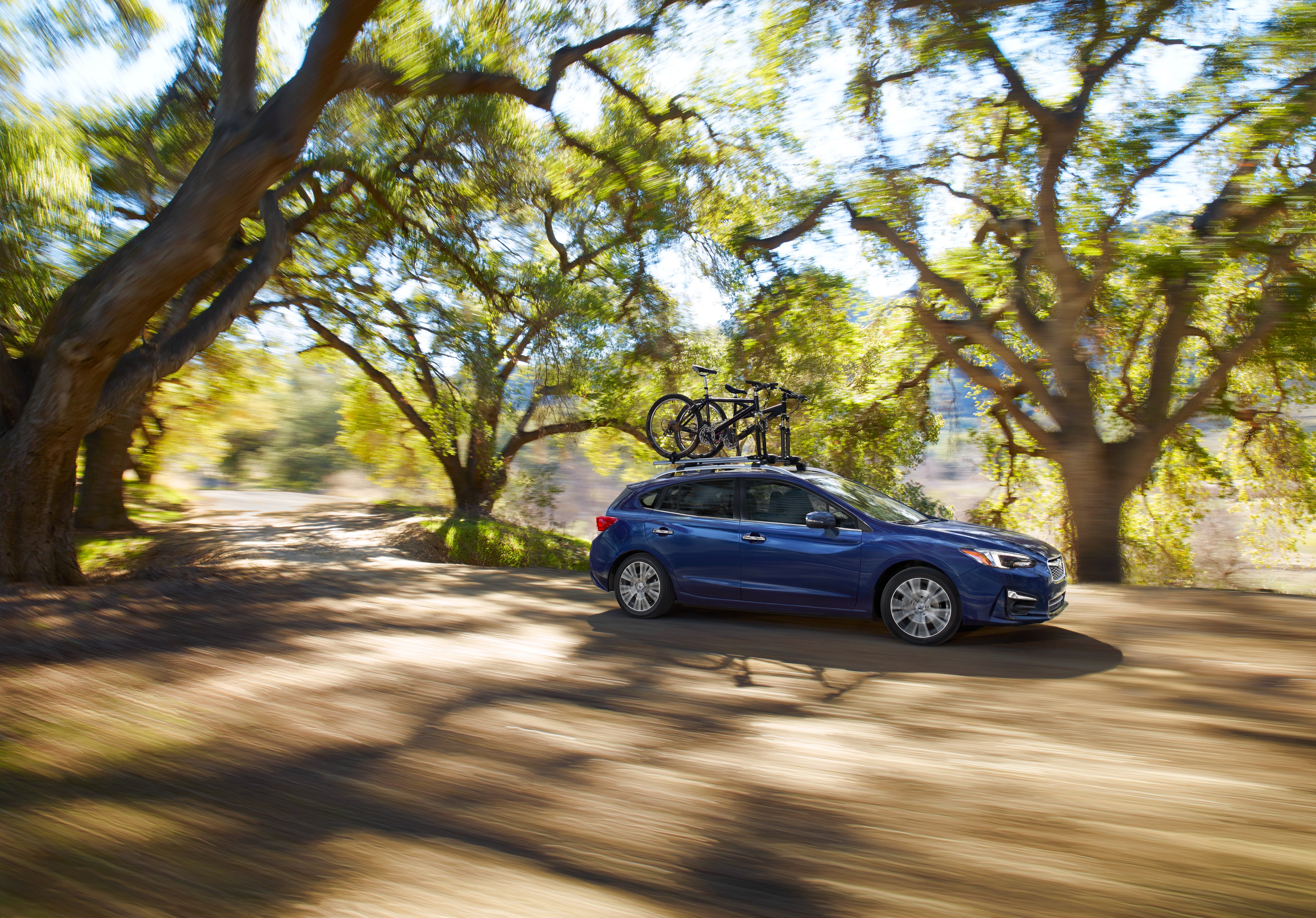 Blue Subaru Impreza with bikes on roof rack HD Wallpaper