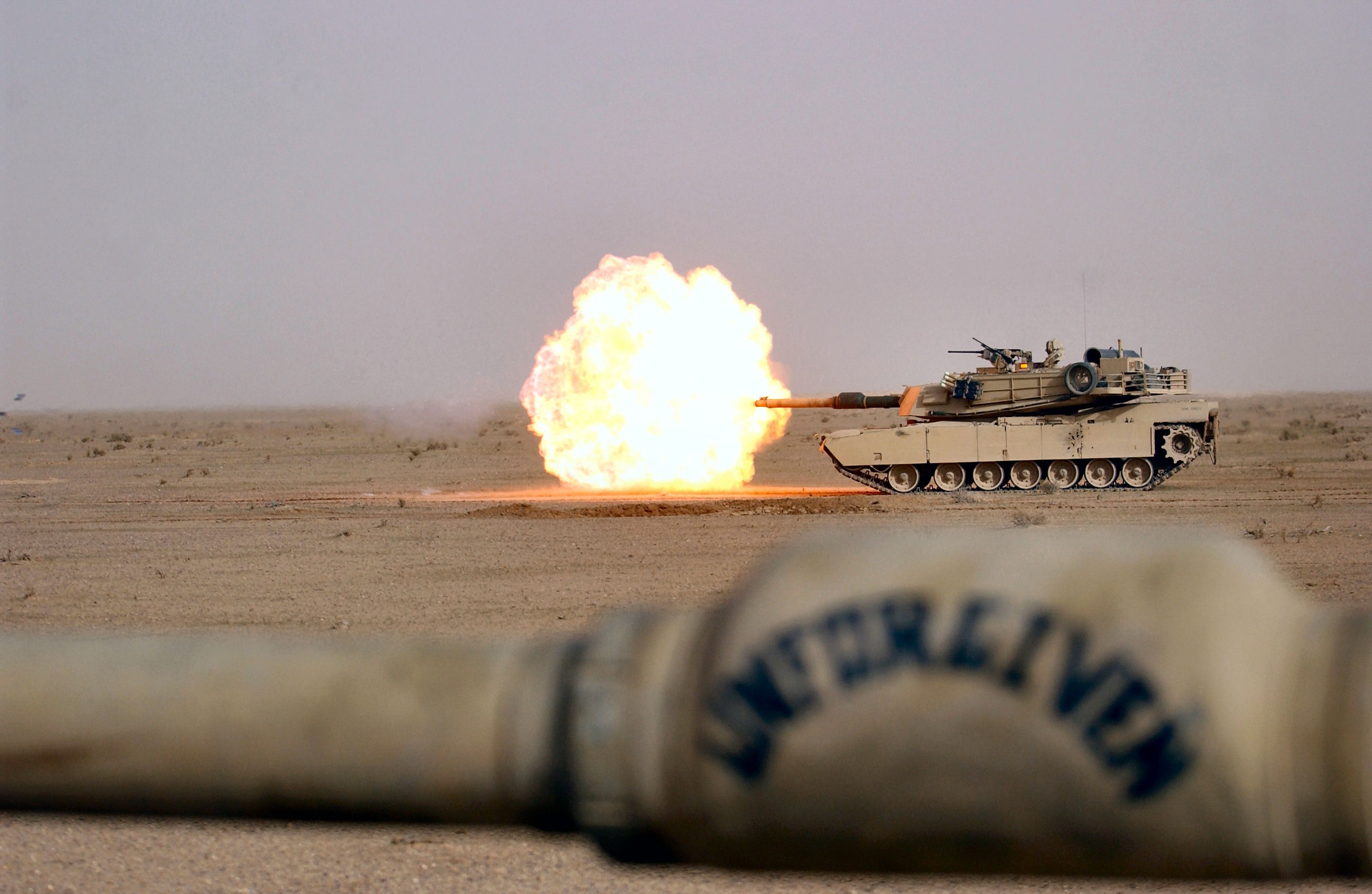 M1 Abrams tank firing a round in a desert HD Wallpaper