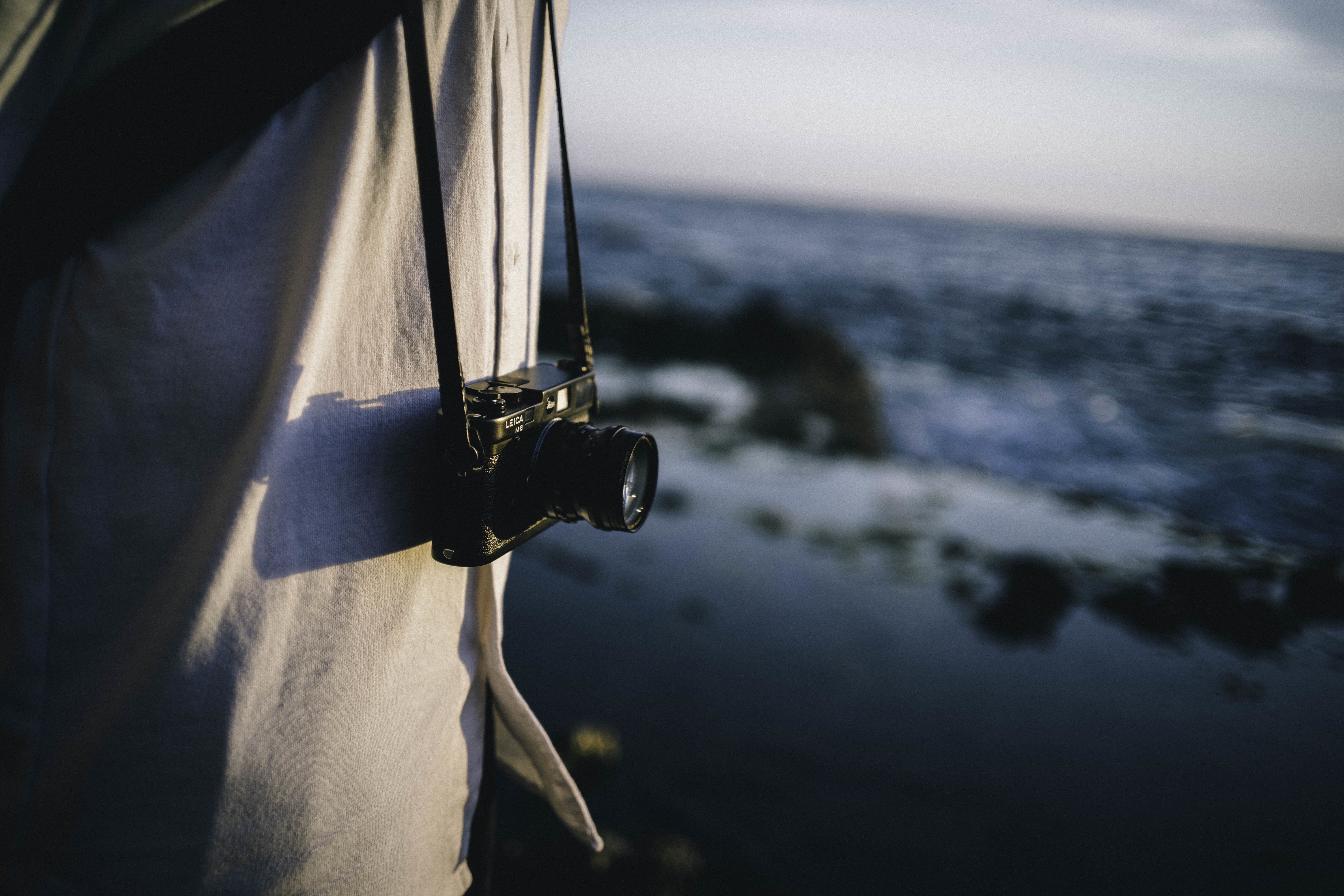 Person with Leica camera by the sea HD Wallpaper