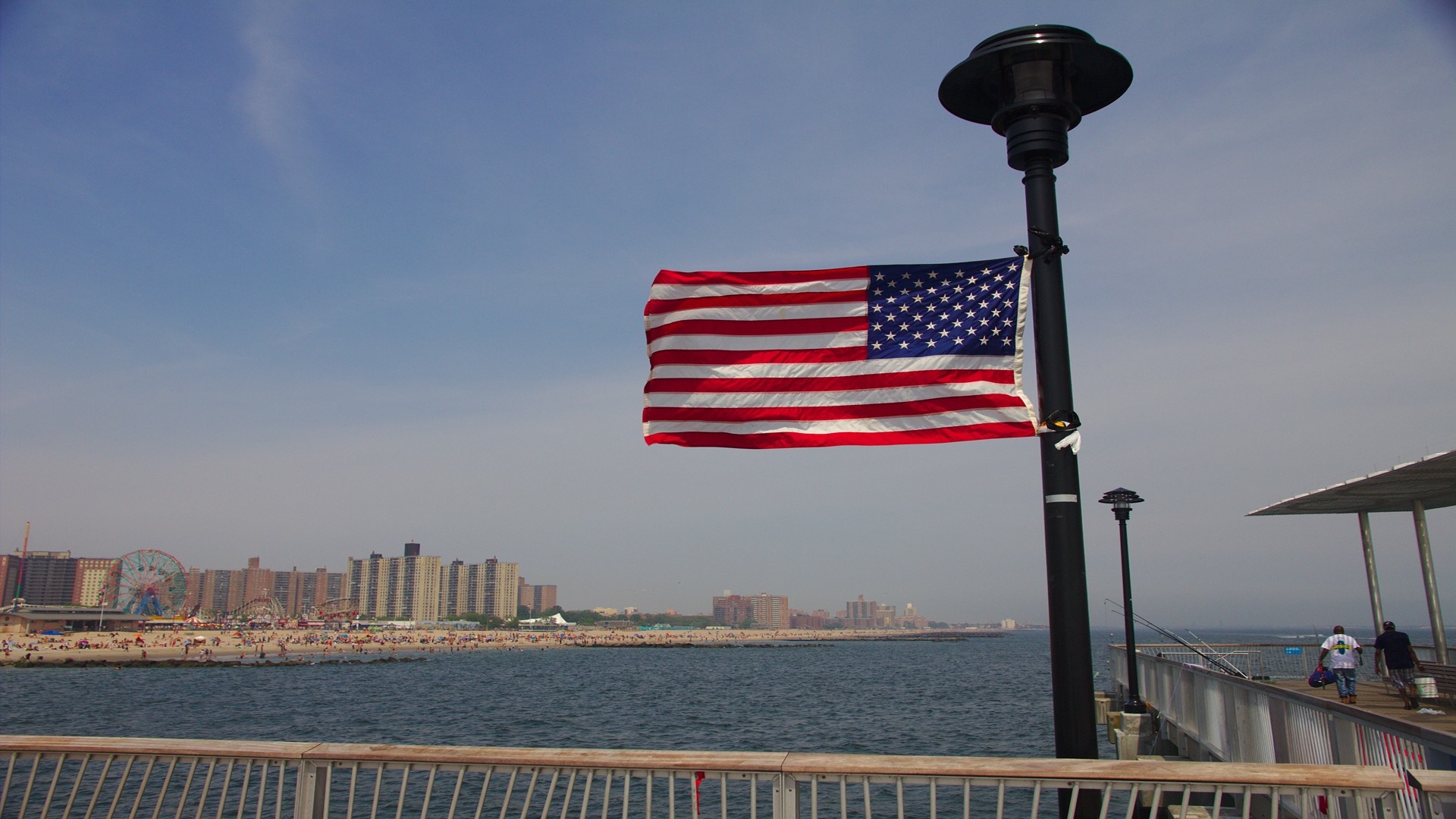 American flag on a pier with Coney Island in the background HD Wallpaper