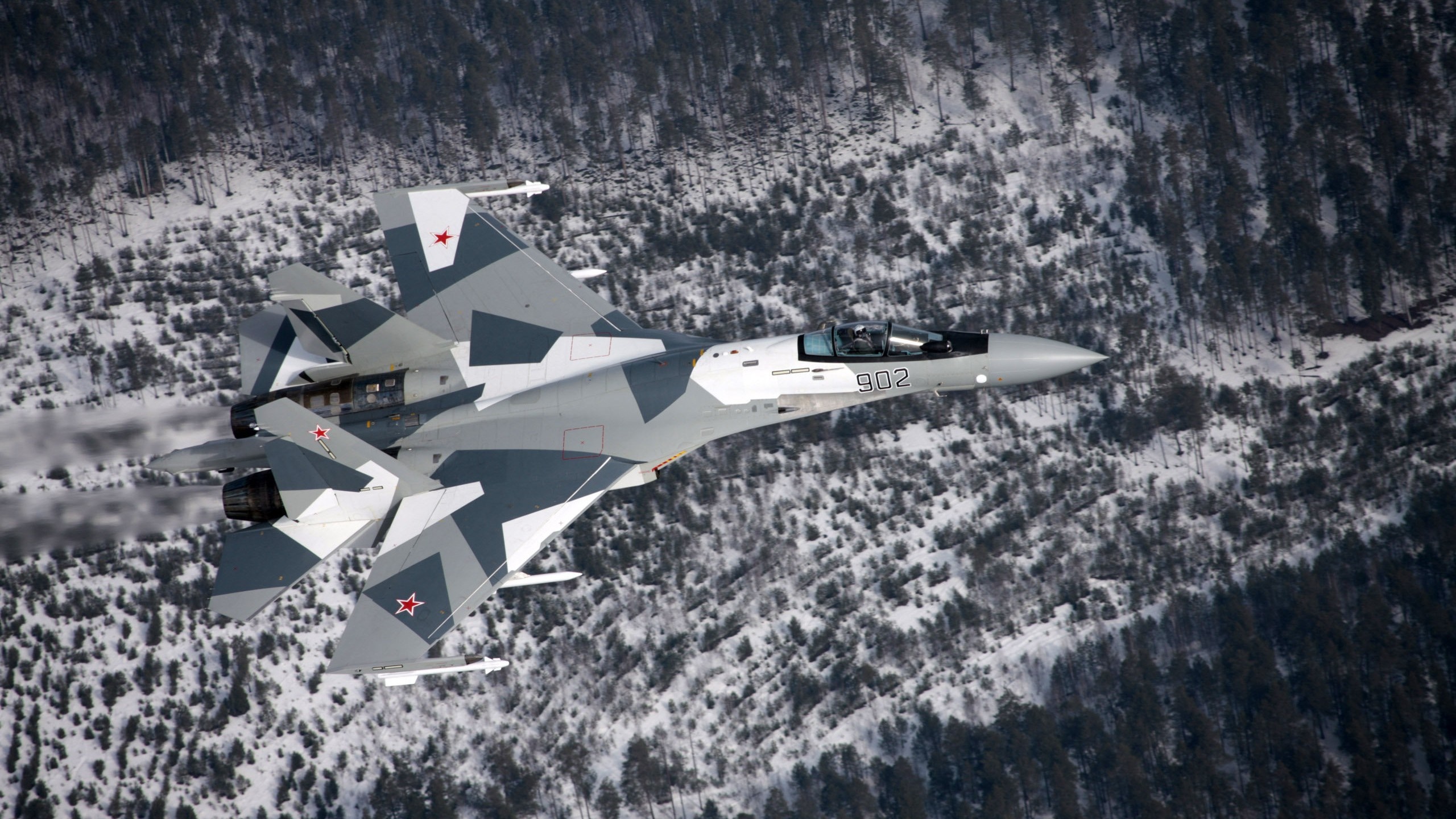 Sukhoi Su-35 fighter jet flying over a snowy forest HD Wallpaper