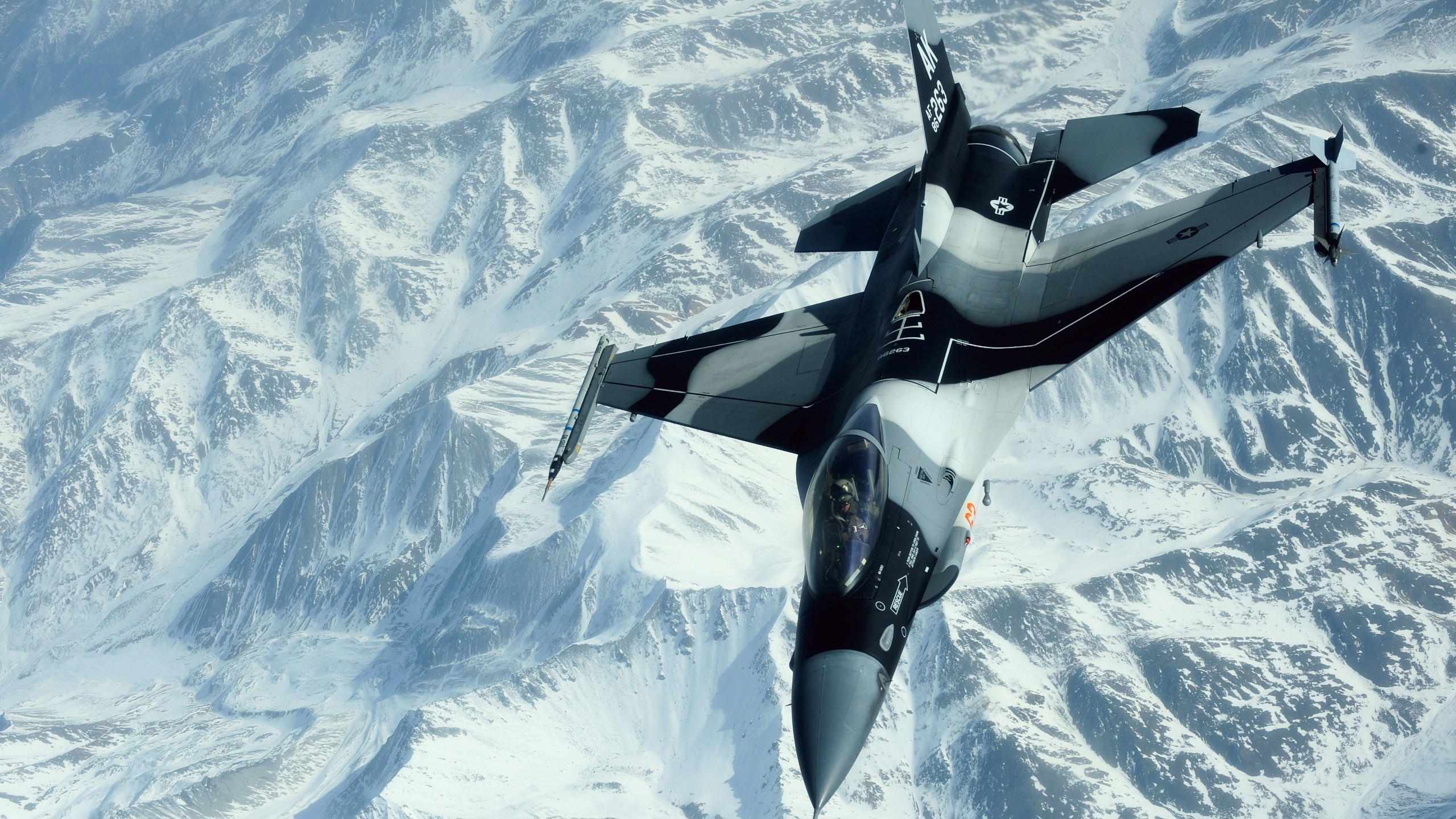 F-16 Fighting Falcon flying over snowy mountains HD Wallpaper