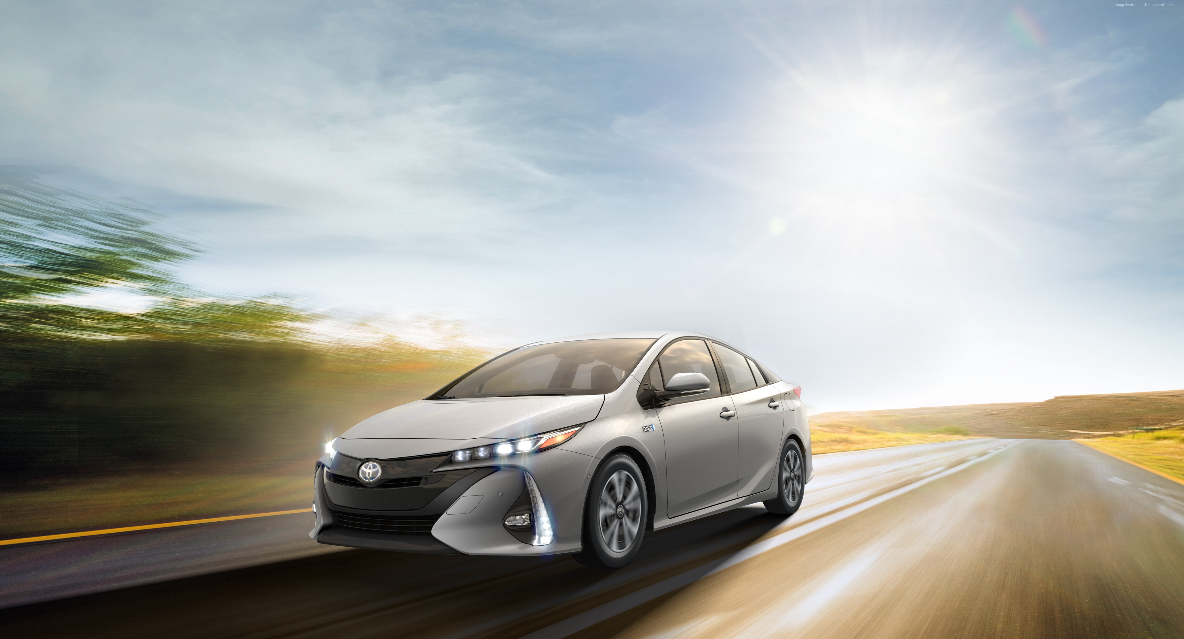 Silver Toyota Prius Prime driving on a sunny road HD Wallpaper