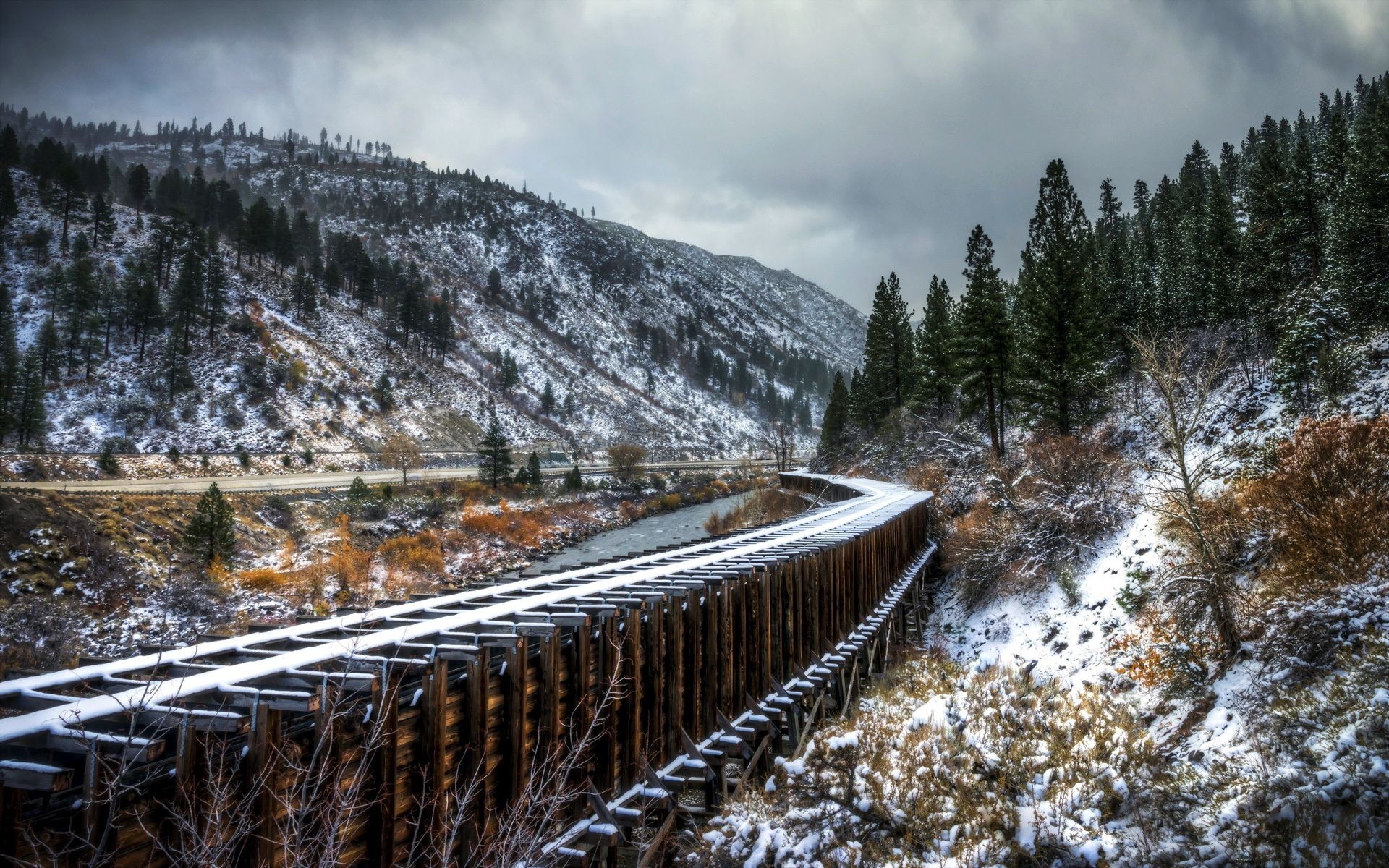 Snowy railway bridge over a river in a mountain valley HD Wallpaper