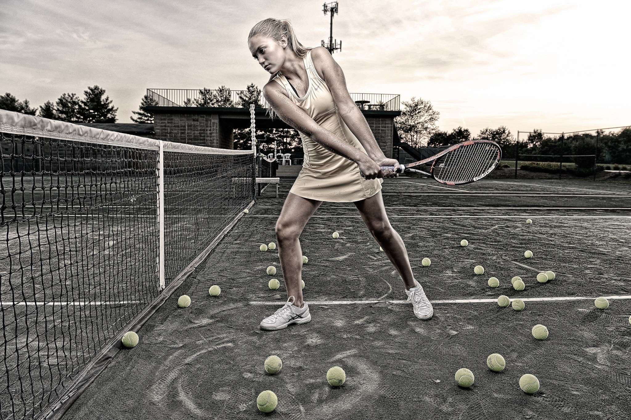 Woman playing tennis on a court with many balls HD Wallpaper
