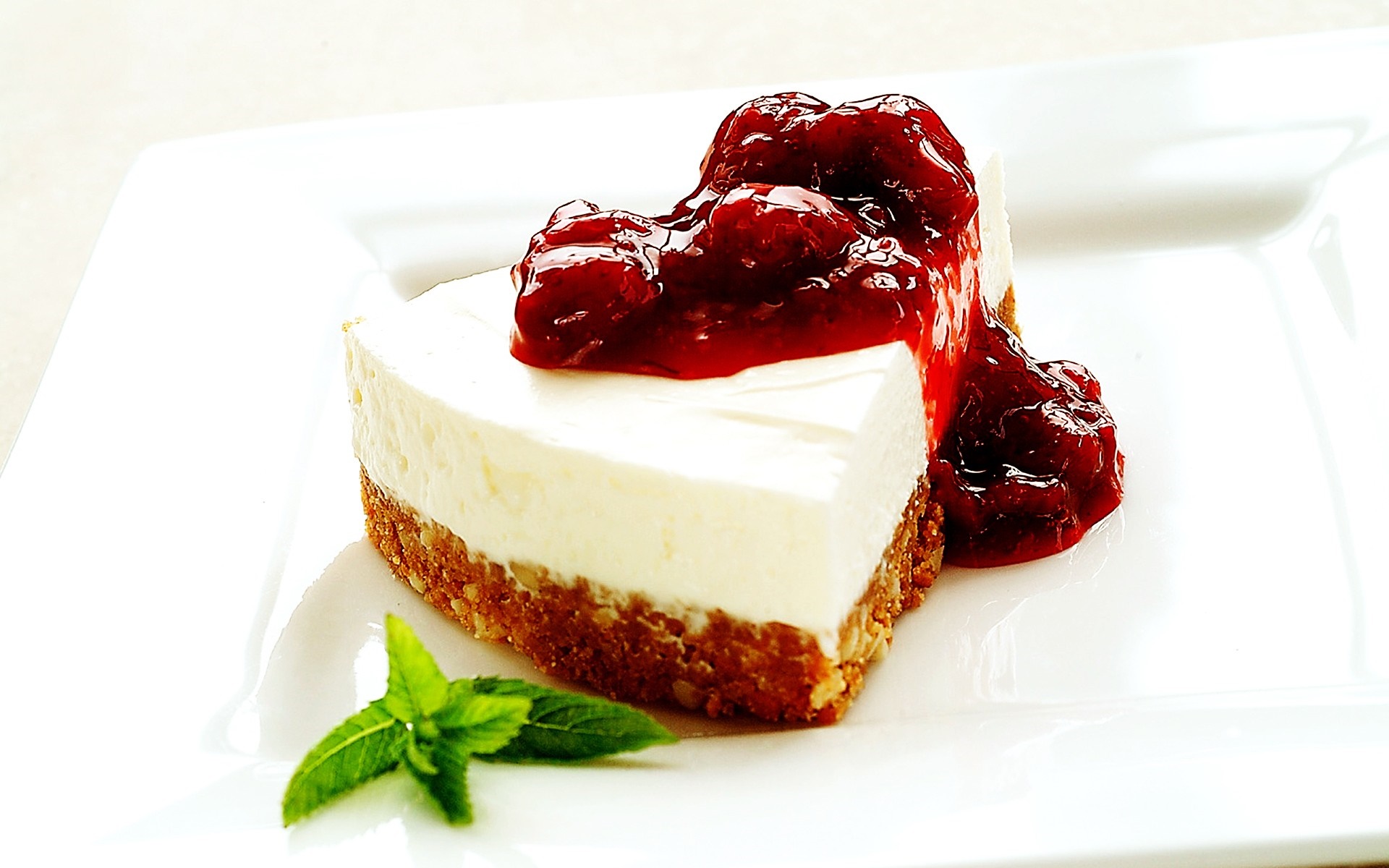 Slice of cheesecake with cherry topping and mint leaf HD Wallpaper
