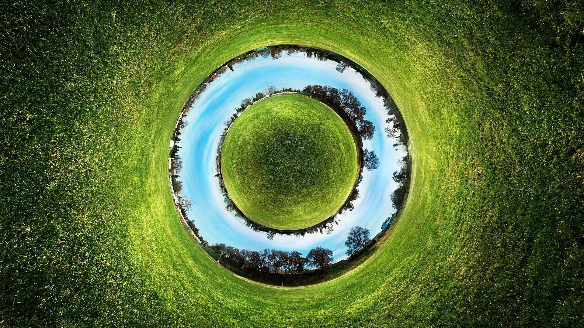 Tiny planet effect of a grassy field with trees and sky HD Wallpaper