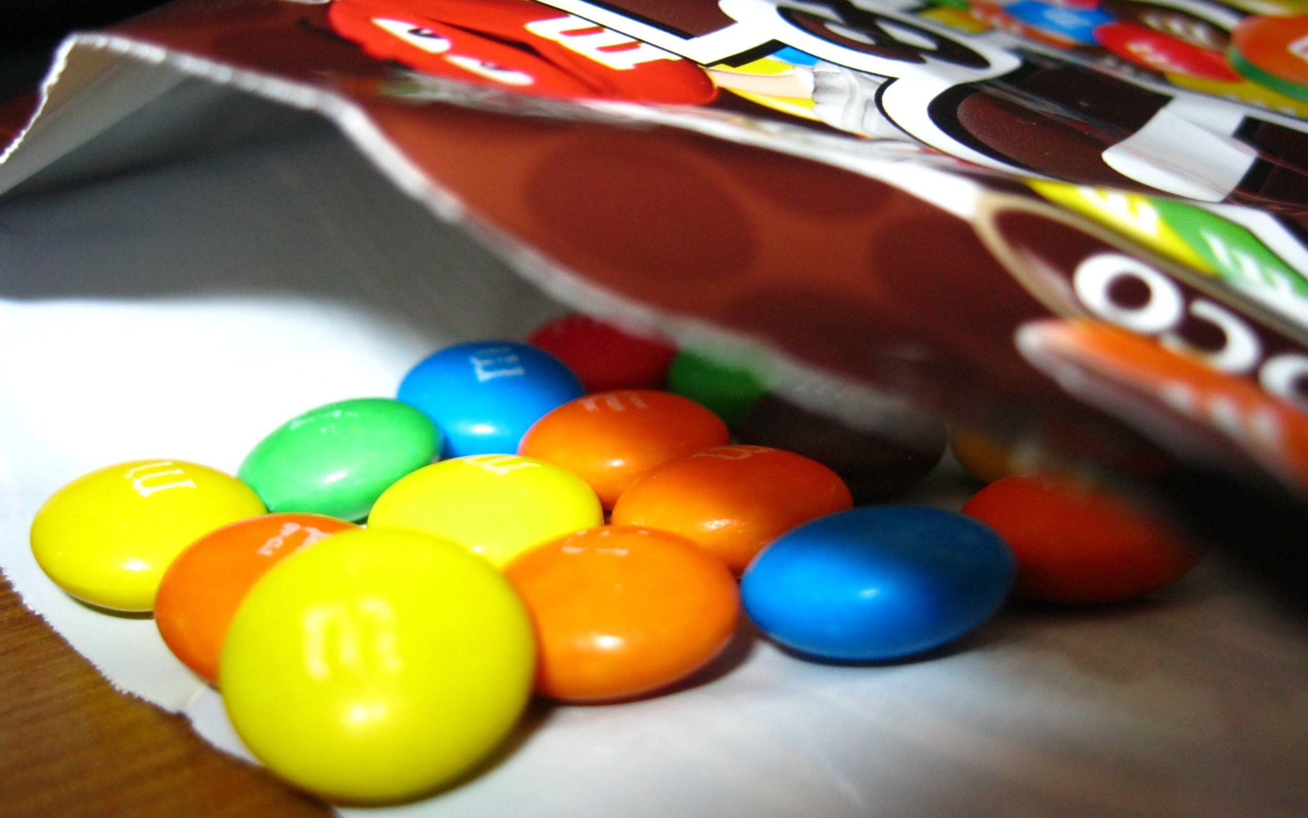 M&M's candies spilling out of a bag HD Wallpaper
