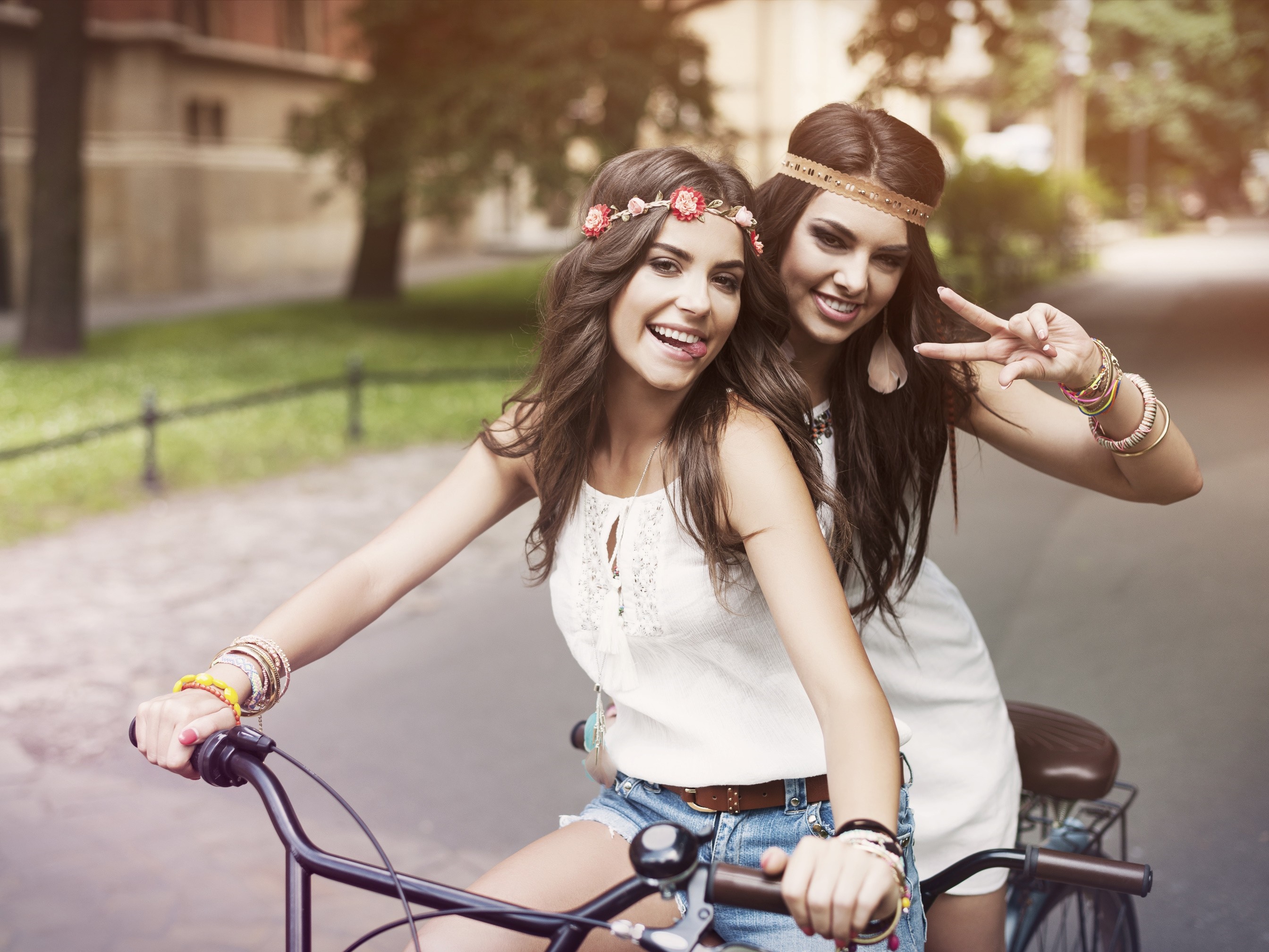 Two young women on a bicycle with flower headbands HD Wallpaper