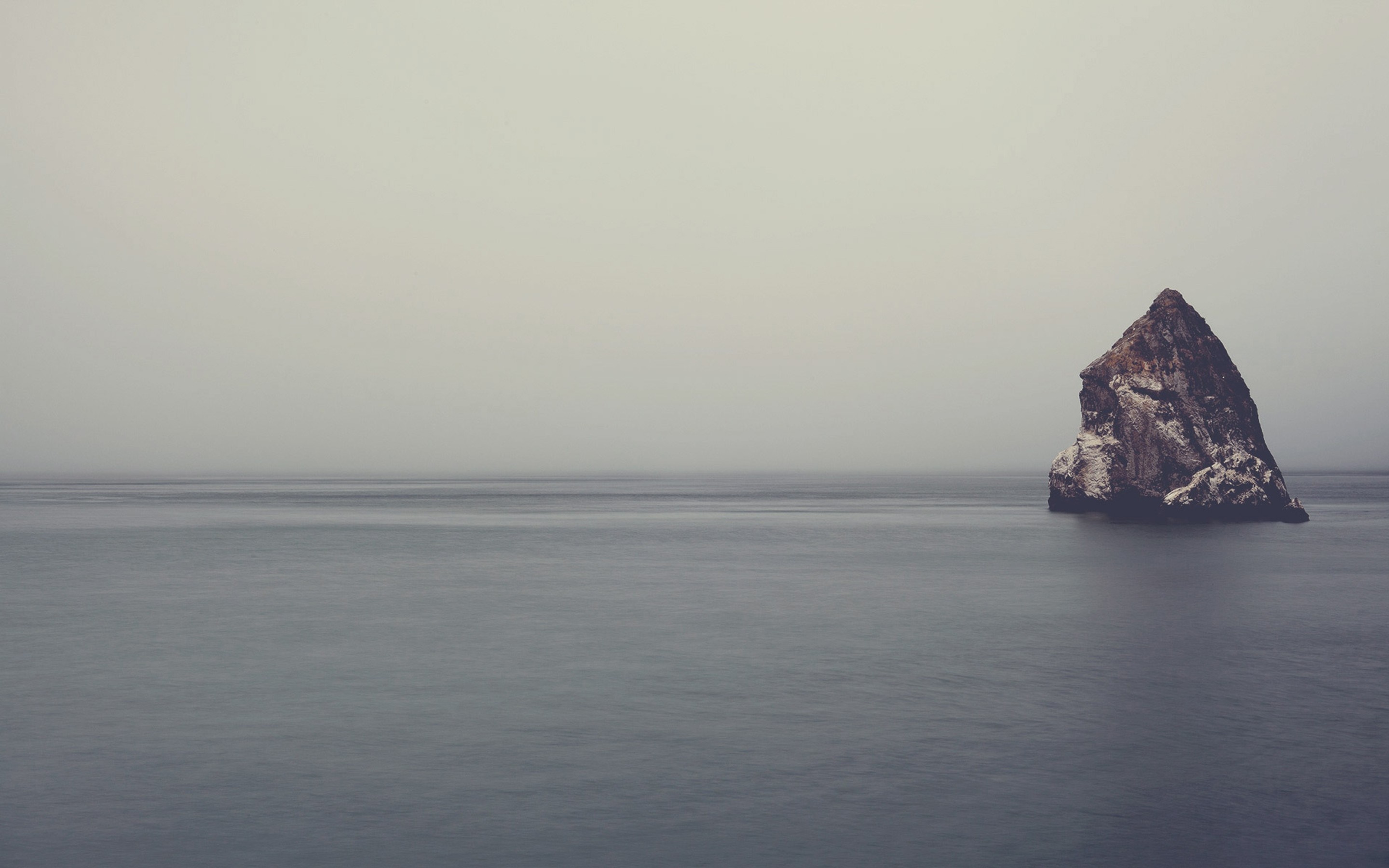 Rock formation in the sea with fog HD Wallpaper