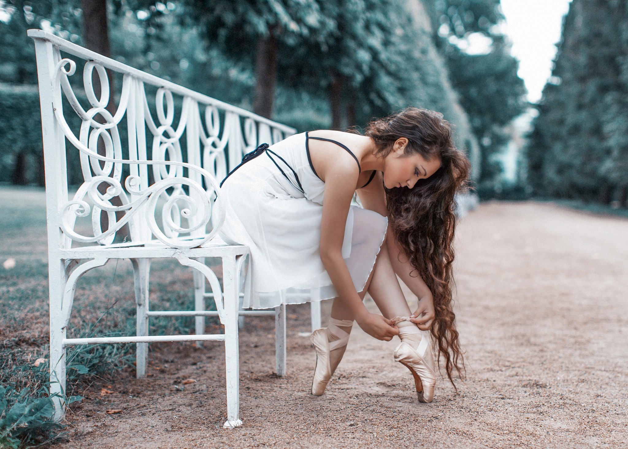 Ballerina tying pointe shoes on a park bench HD Wallpaper