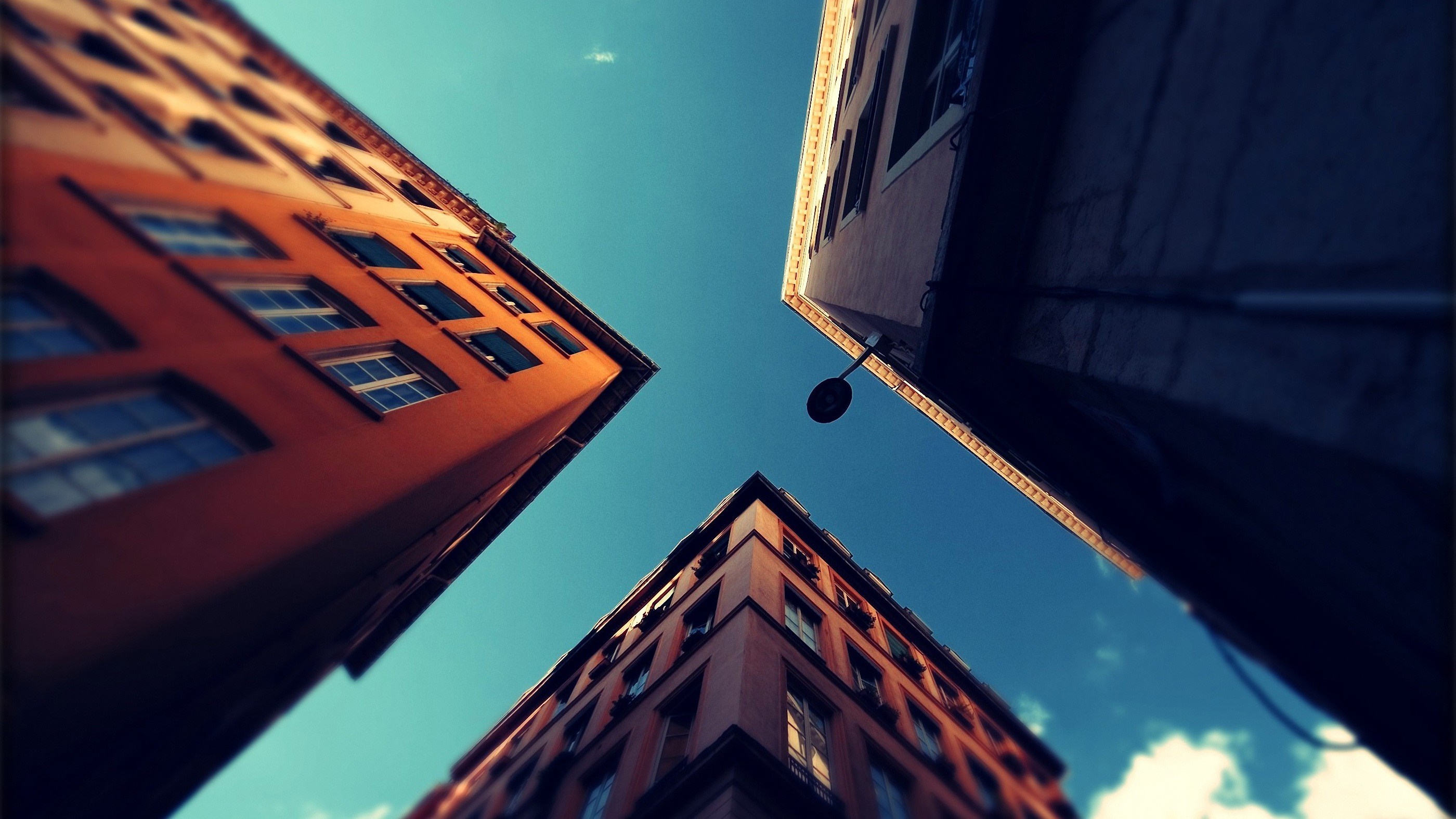 Buildings viewed from below against a blue sky HD Wallpaper
