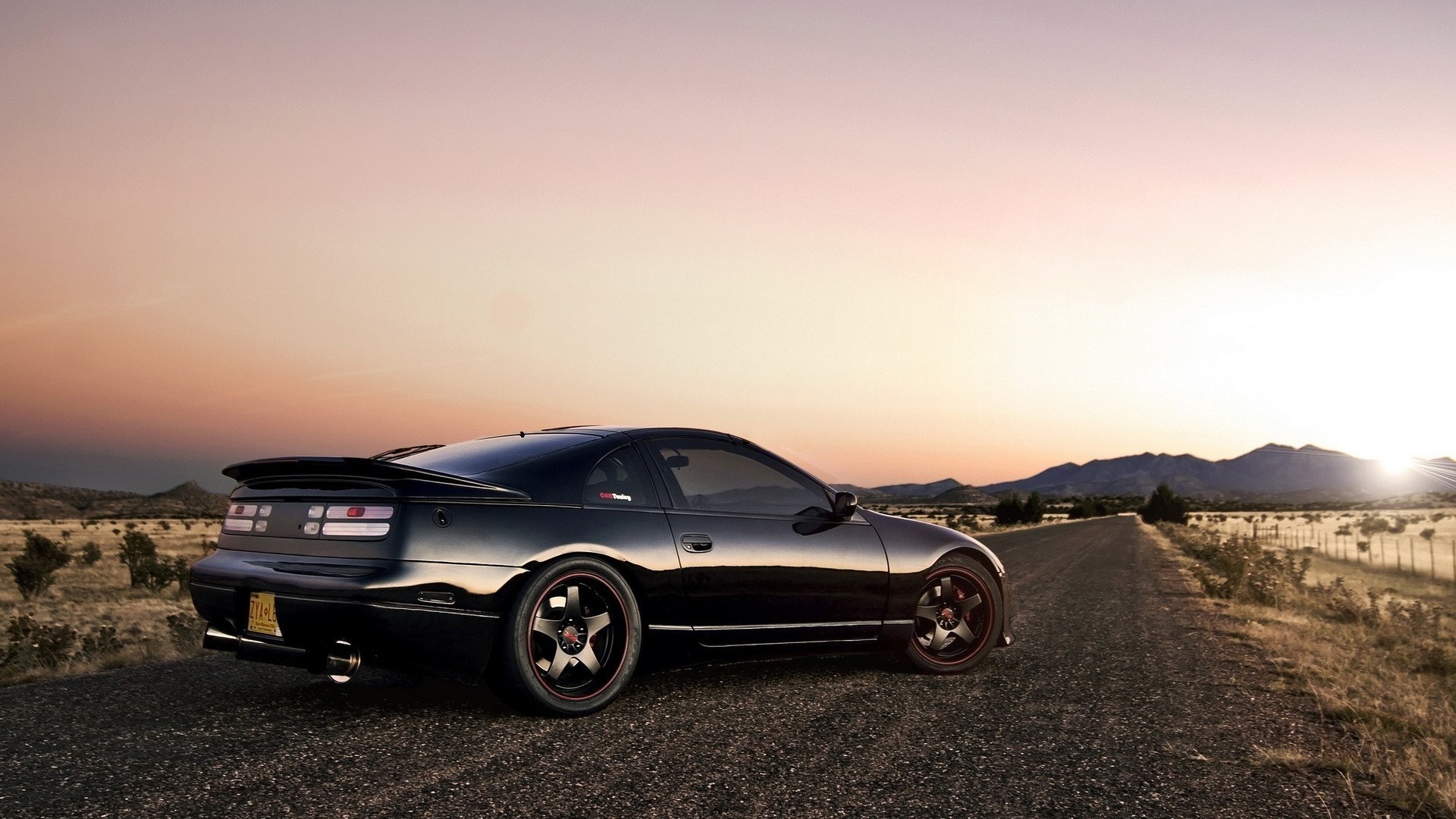 Black Nissan 300ZX parked on a dirt road at sunset HD Wallpaper