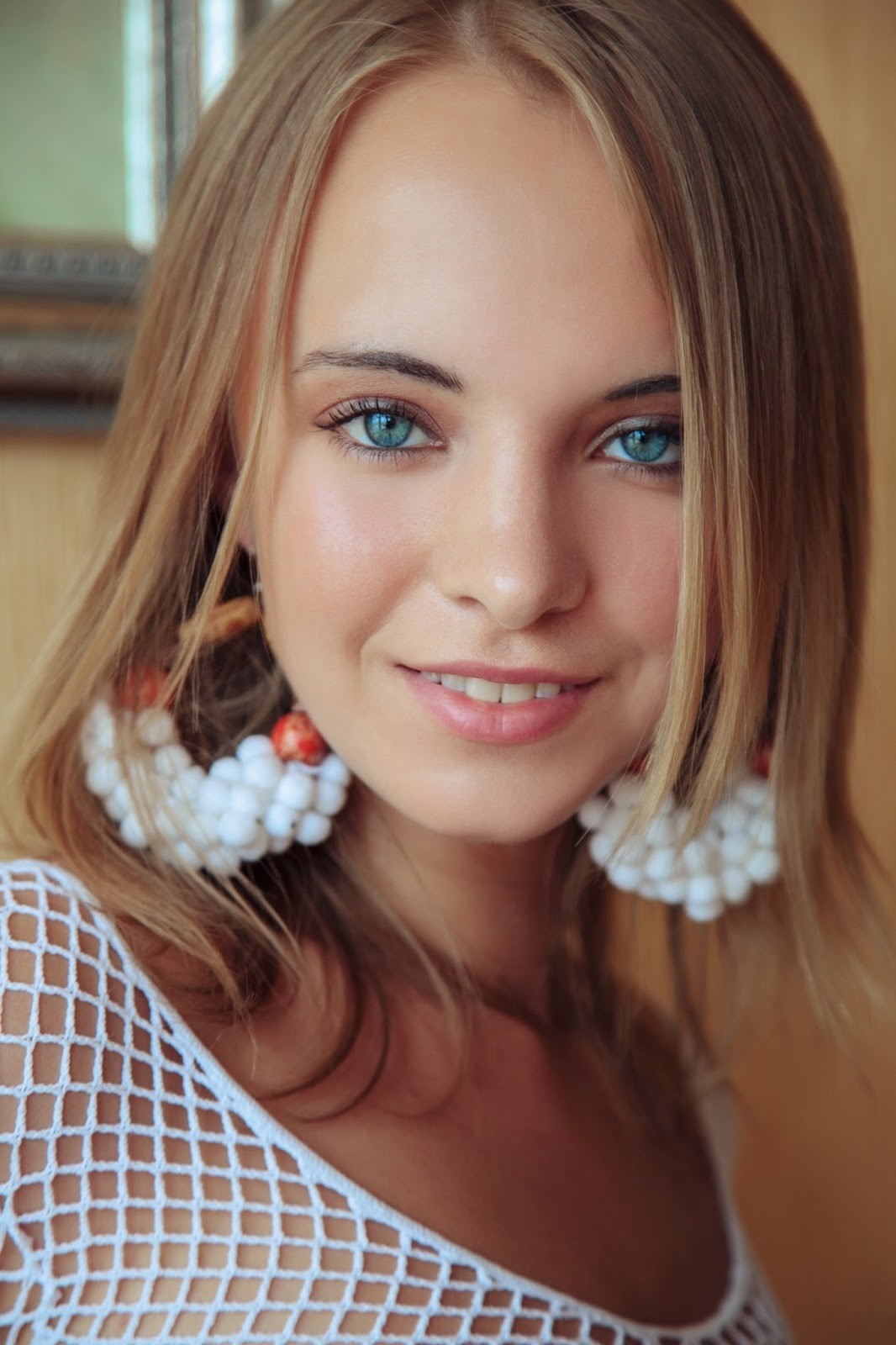Young woman with blonde hair and blue eyes wearing large earrings HD Wallpaper