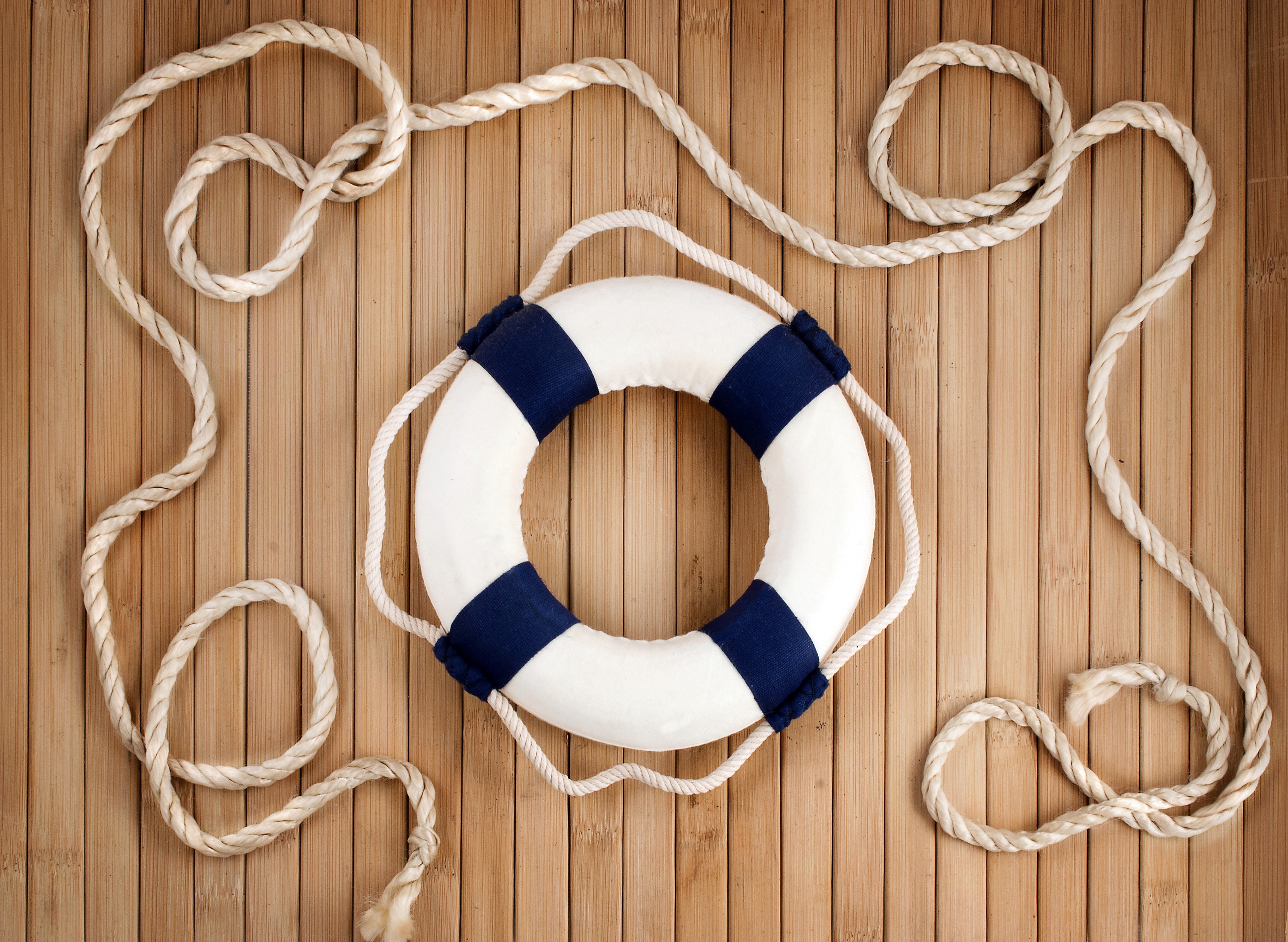 Lifebuoy with rope on a wooden background HD Wallpaper