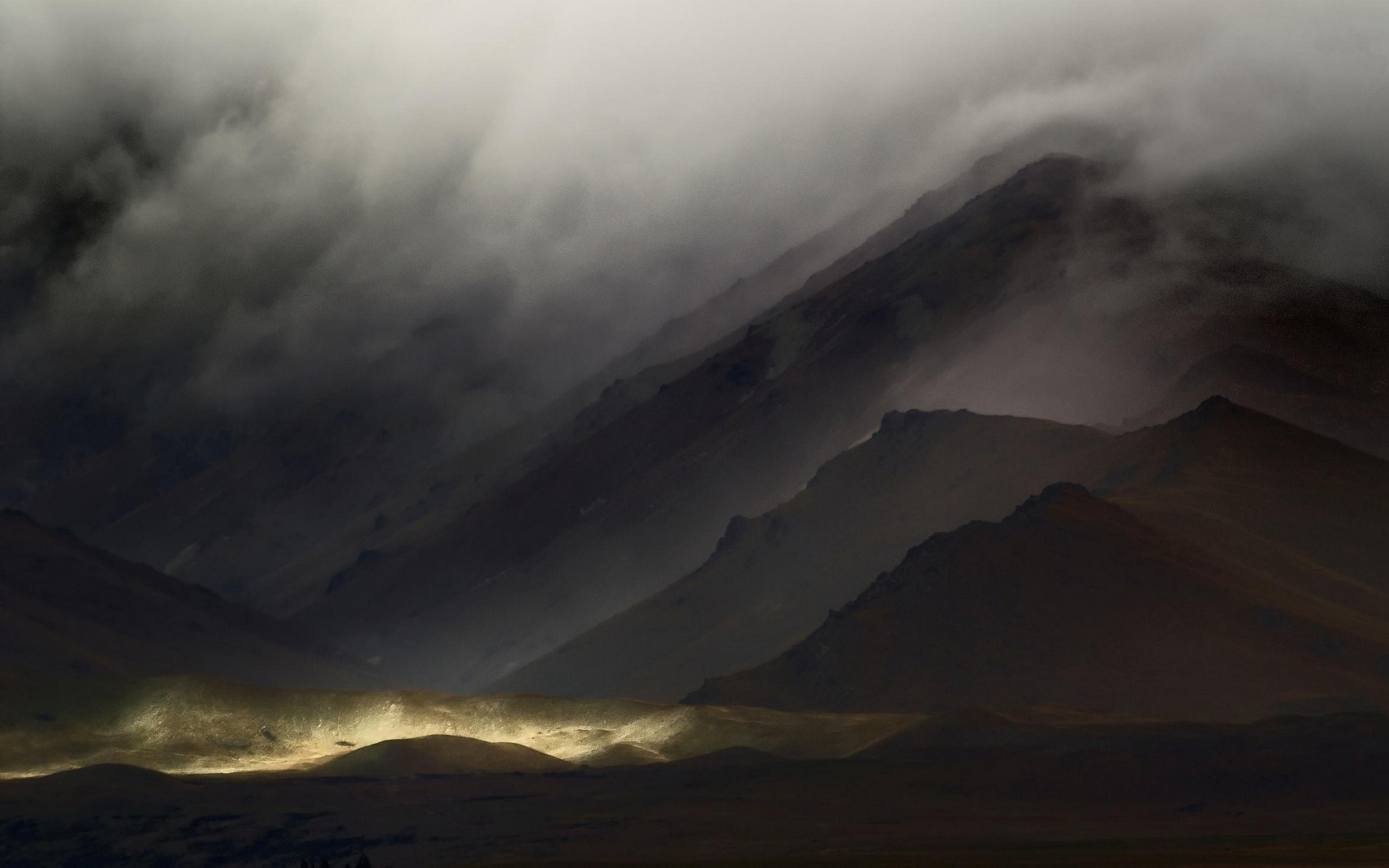 Dark mountains shrouded in mist with a beam of light HD Wallpaper