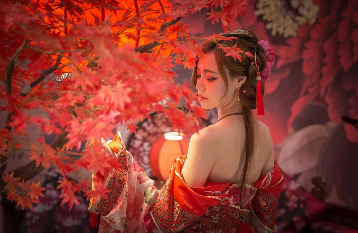 Woman in traditional red Asian dress with red leaves HD Wallpaper