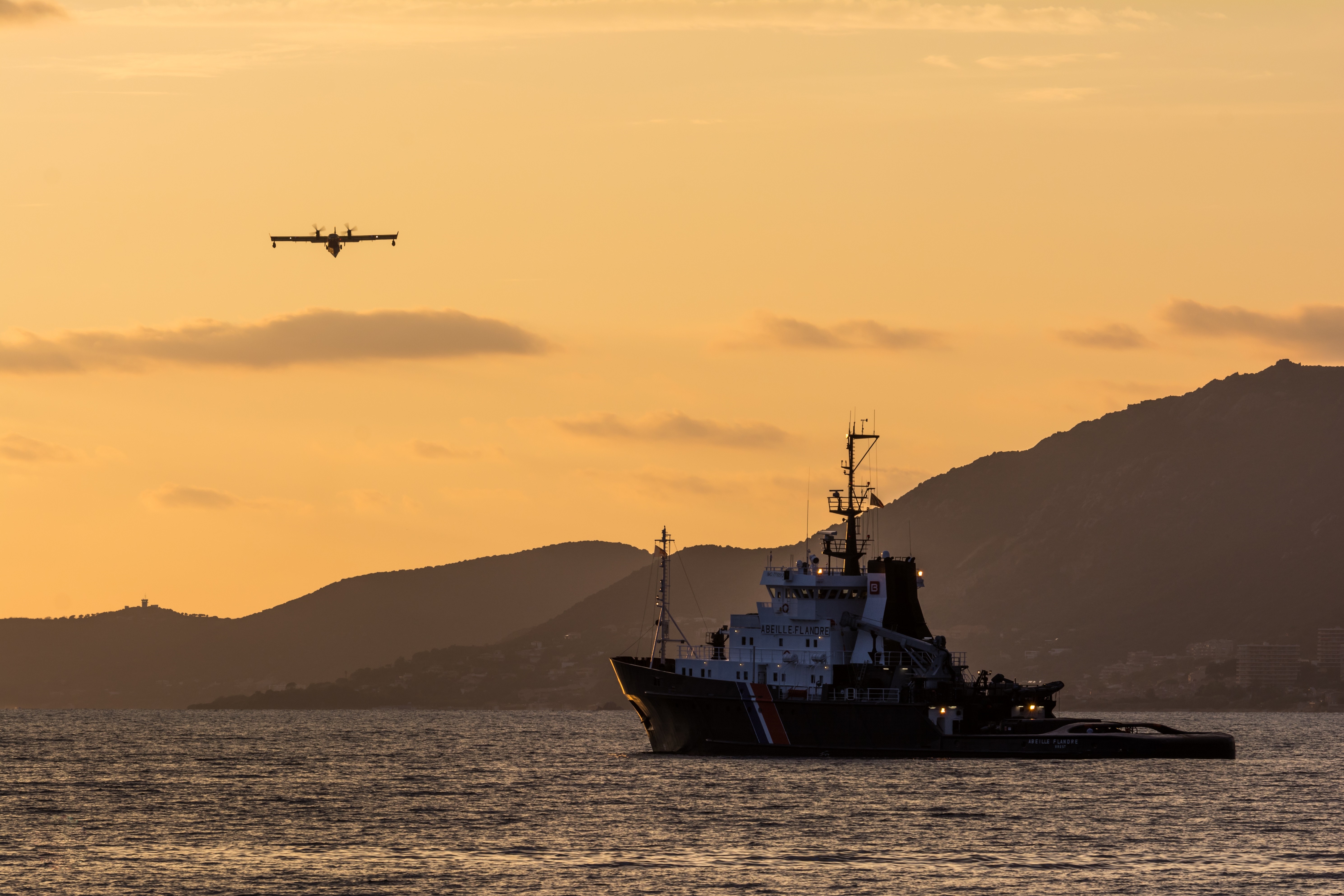 Seaplane and ship at sunset over the sea HD Wallpaper
