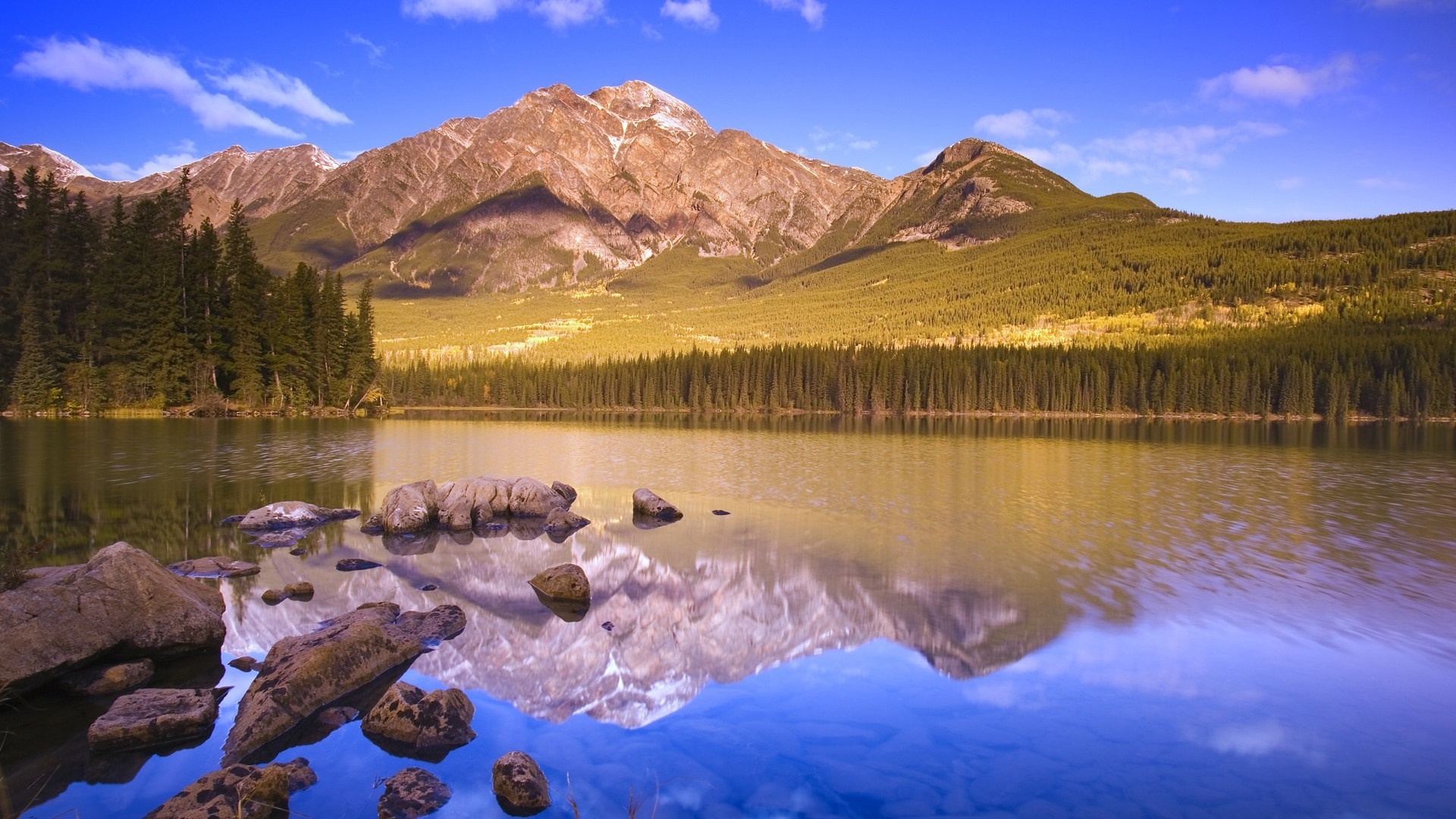 Mountain lake reflection with rocks in foreground HD Wallpaper