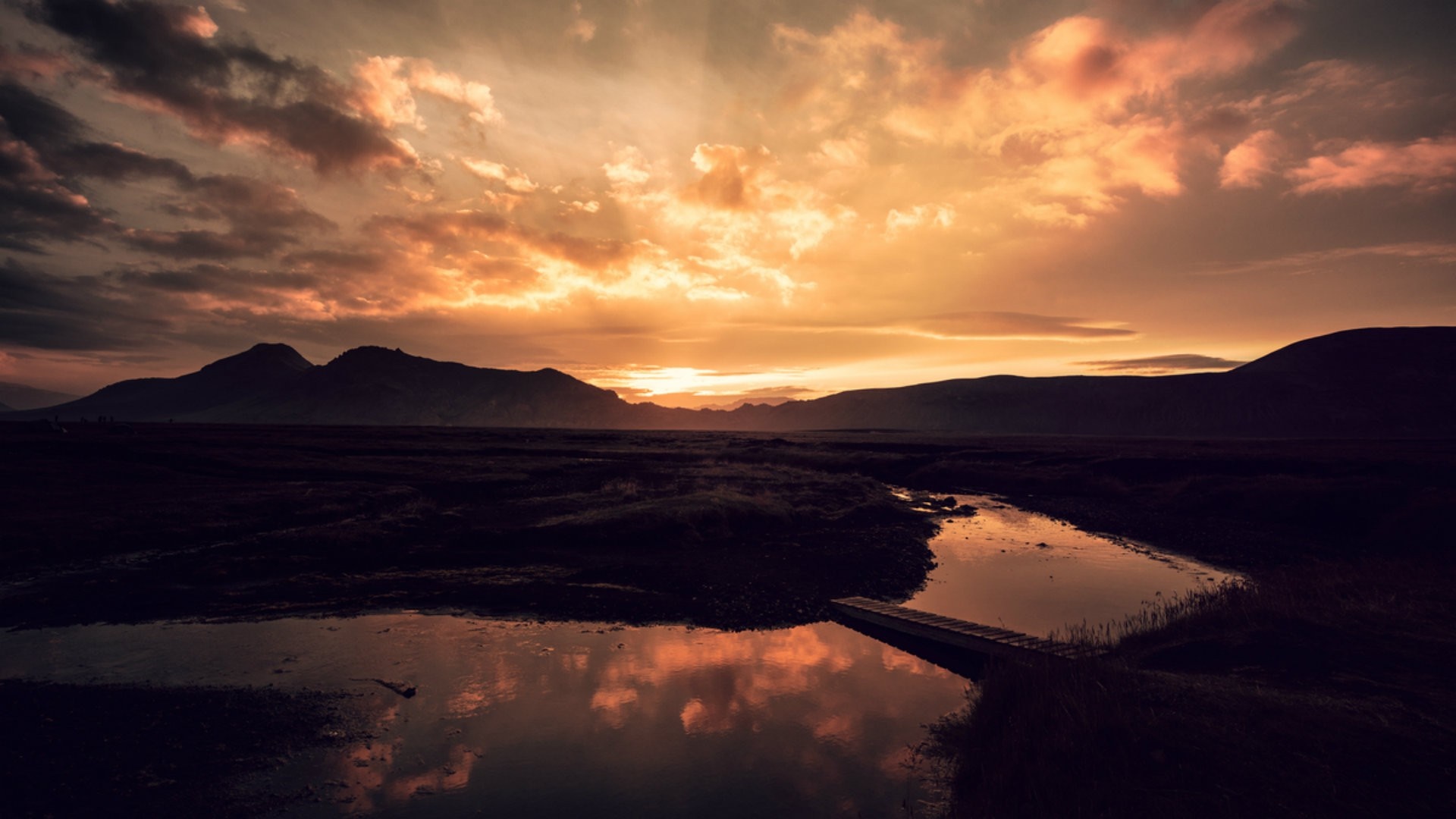 Sunset over mountains with reflection in water and bridge HD Wallpaper