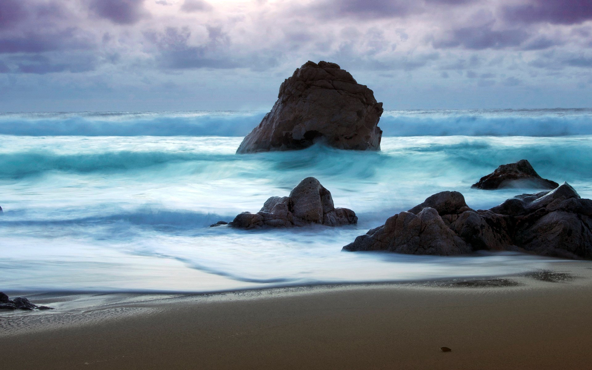 Ocean waves crashing on rocks at a beach HD Wallpaper