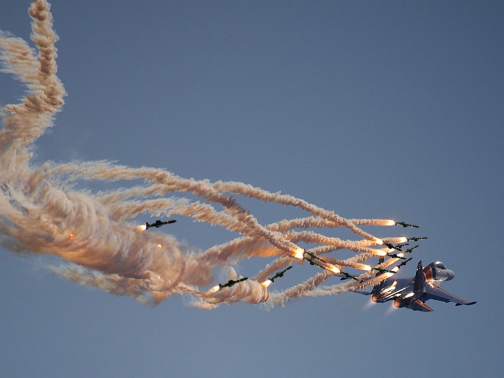 Fighter jet deploying flares during air show HD Wallpaper
