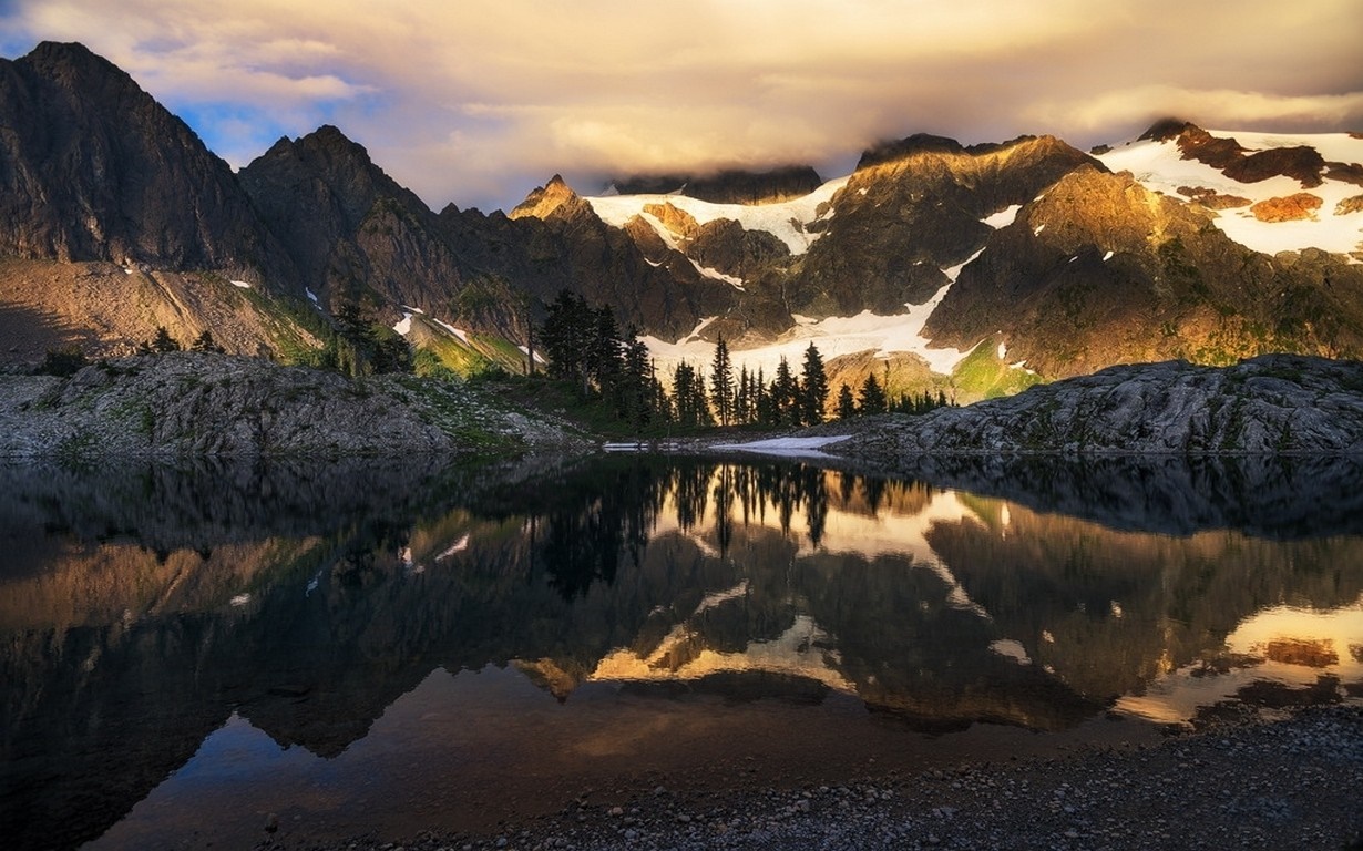 Mountain range reflected in a calm lake at sunset HD Wallpaper
