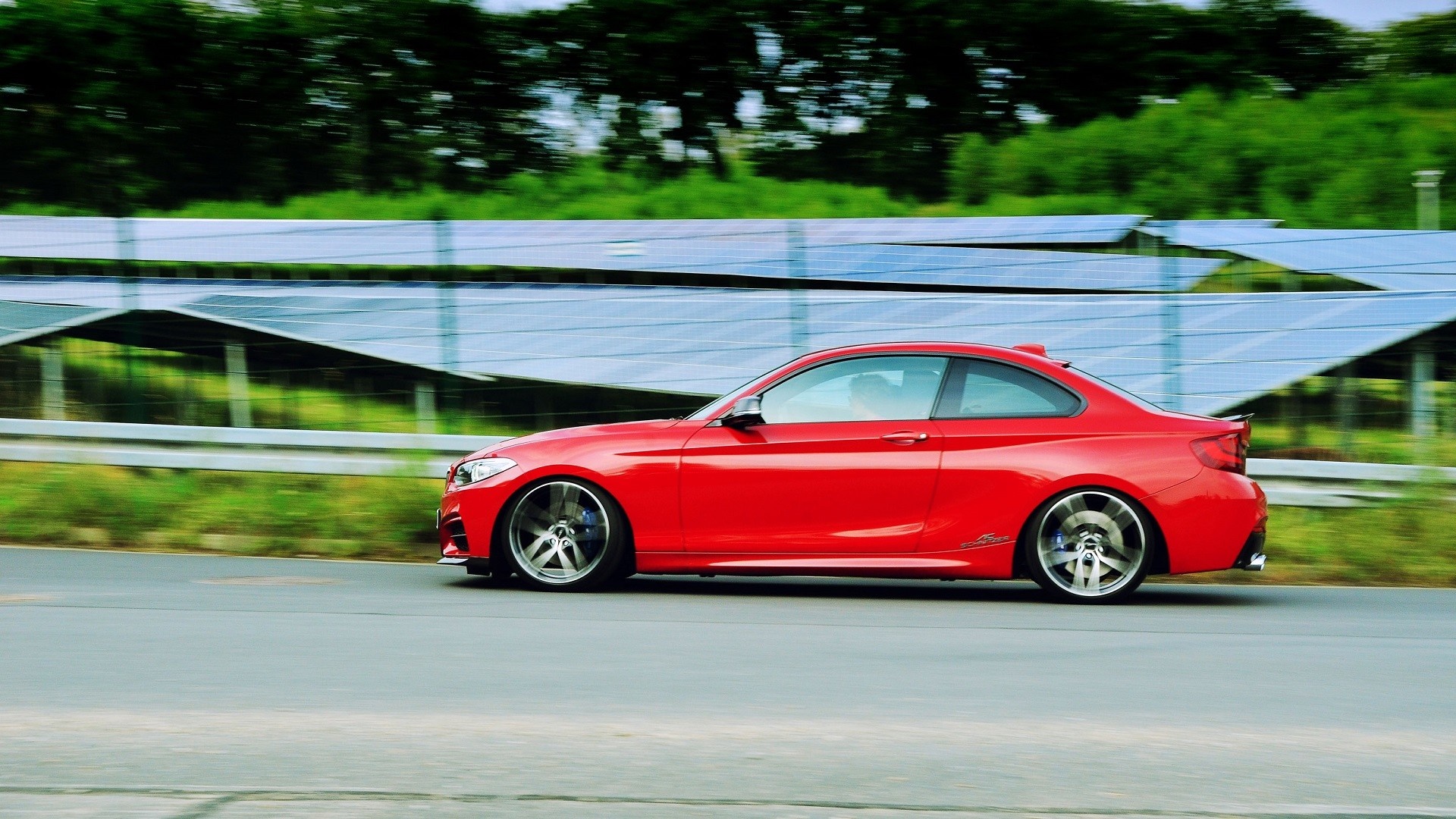 Red BMW sports car driving on a road HD Wallpaper