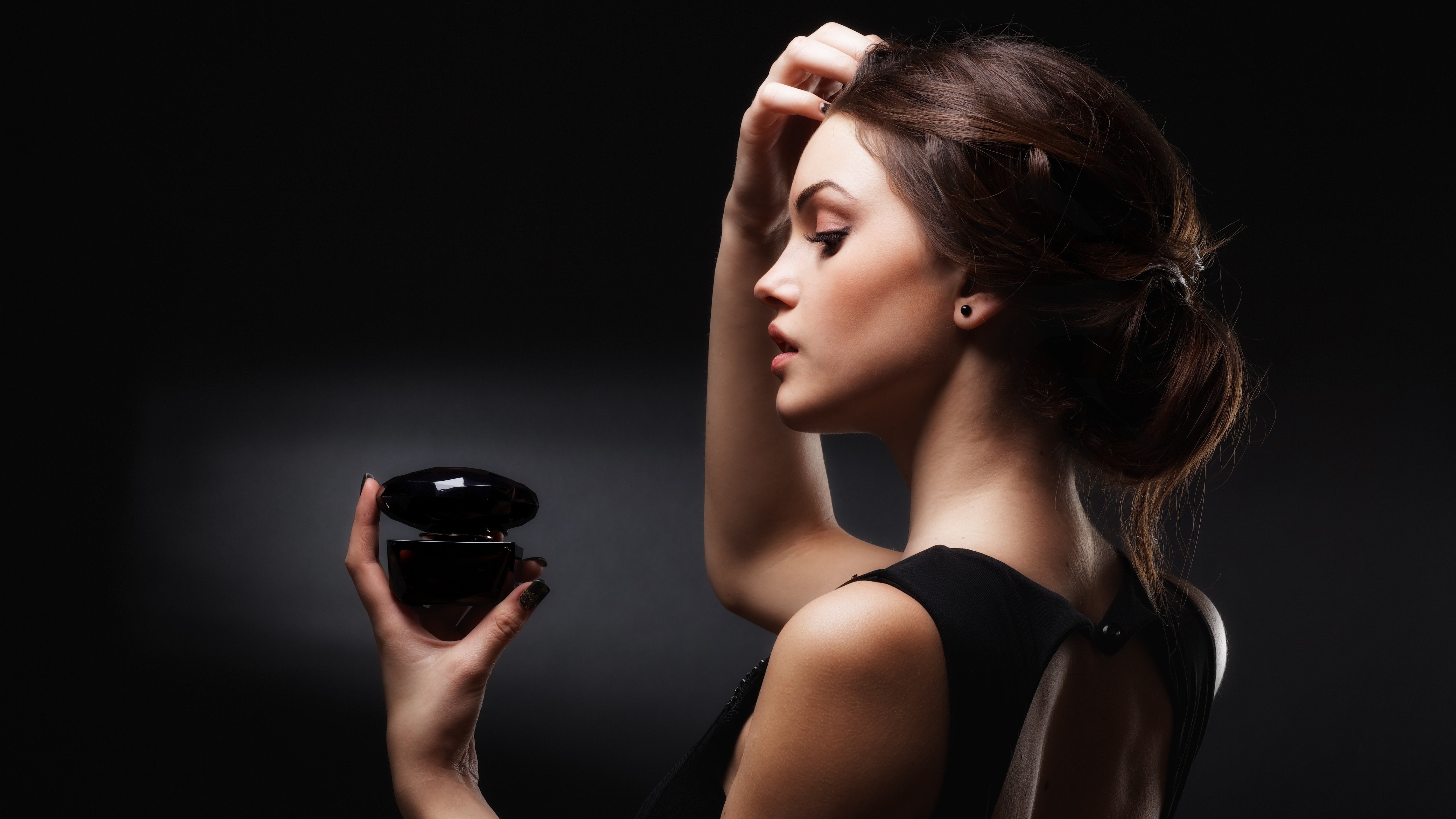 Woman holding a perfume bottle HD Wallpaper
