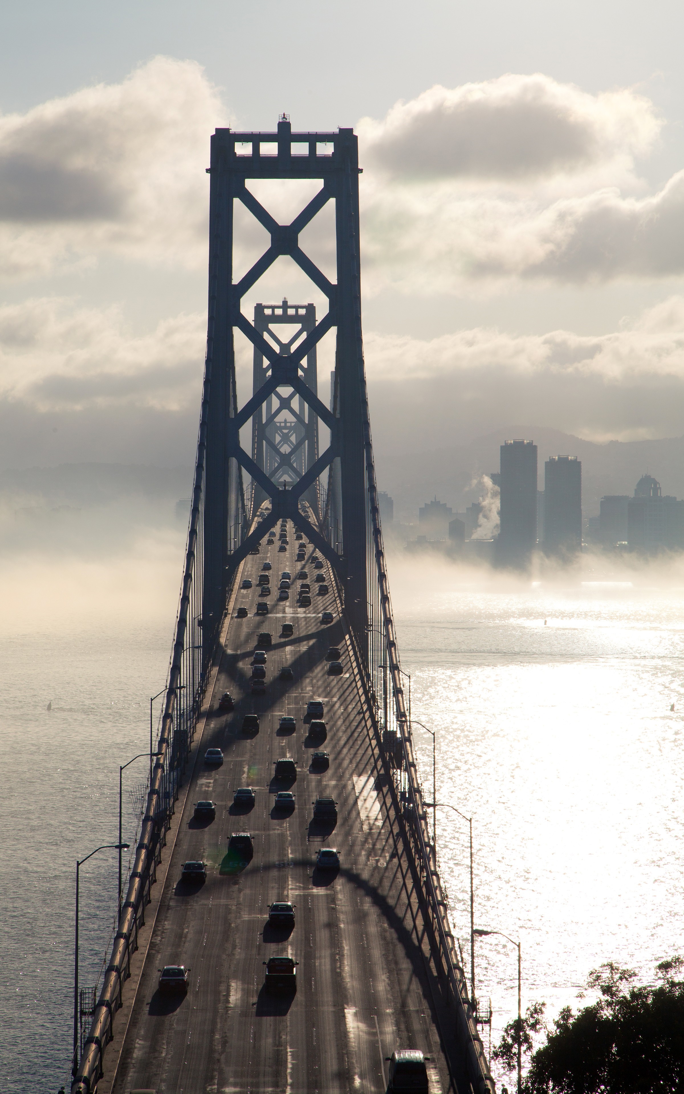 Bay Bridge traffic in San Francisco with fog and city skyline HD Wallpaper