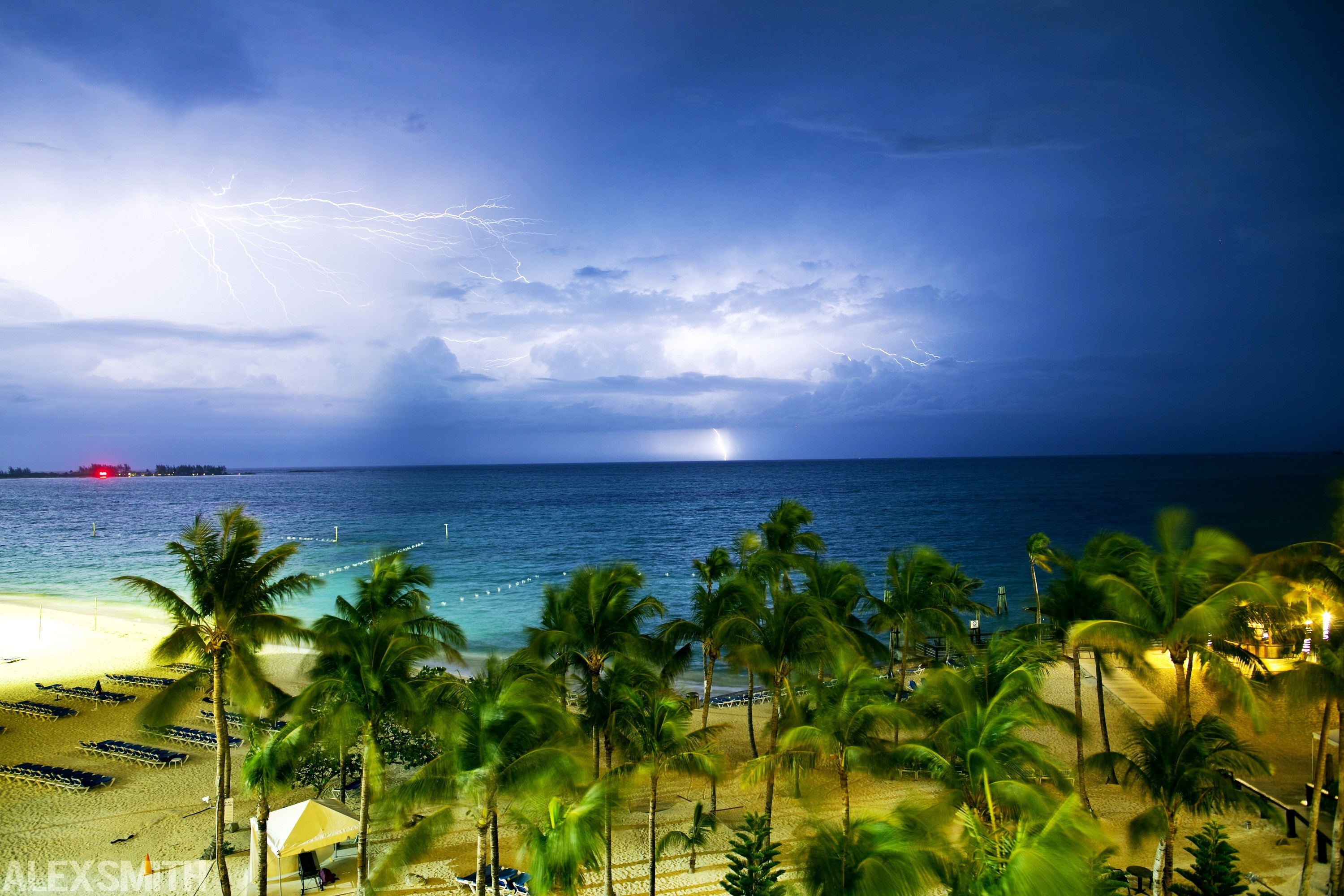 Lightning storm over a tropical beach with palm trees HD Wallpaper