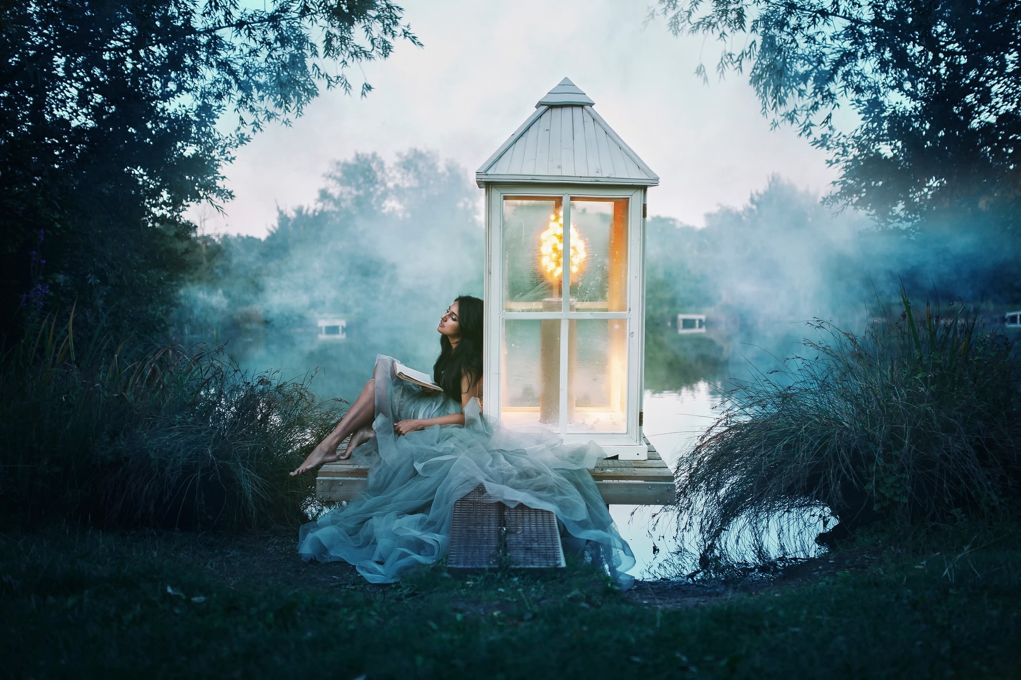Woman reading by a lantern on a misty lake HD Wallpaper