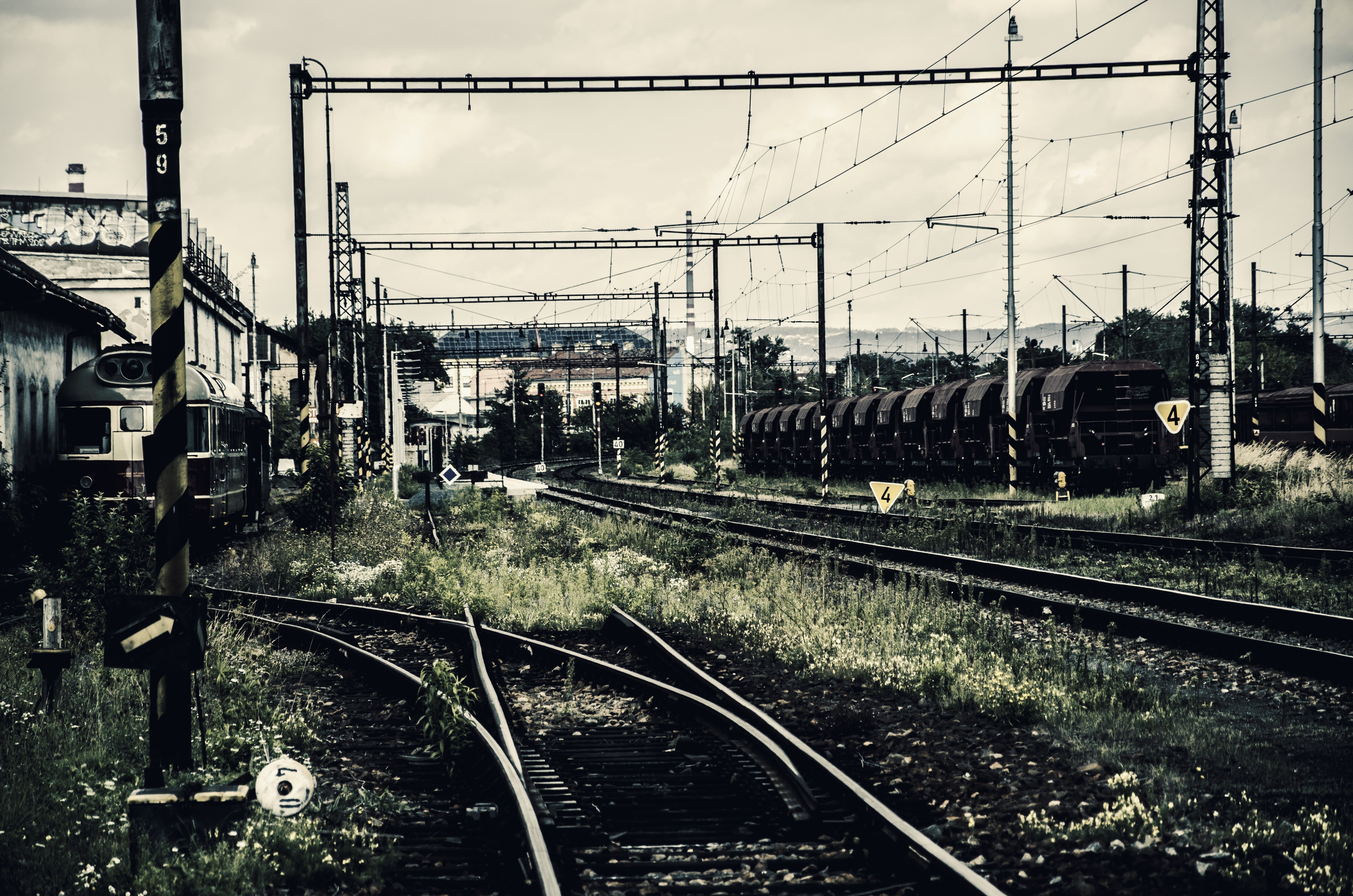Abandoned train tracks and rusted train cars in a rail yard HD Wallpaper