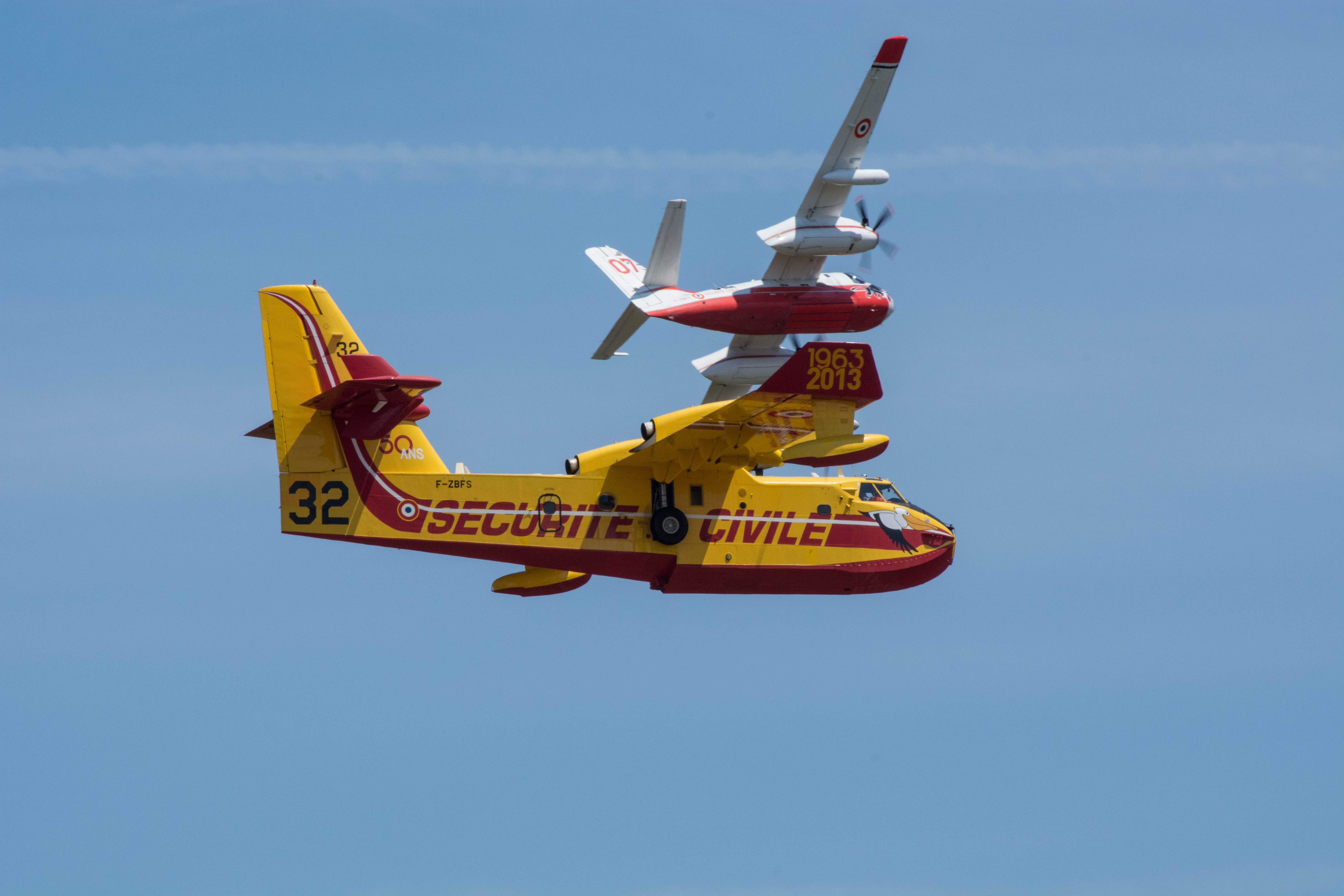 Two airplanes flying in formation against a blue sky HD Wallpaper