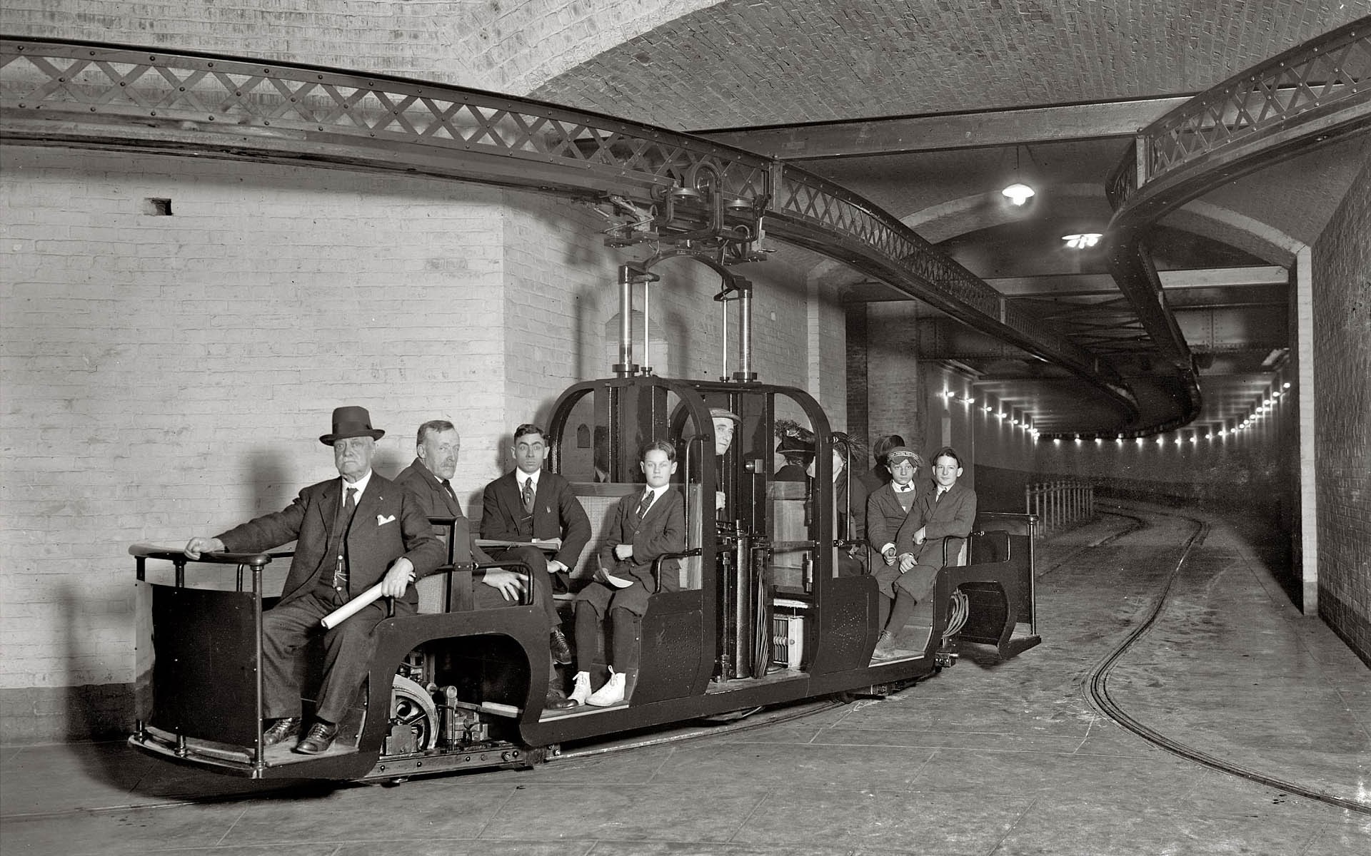 Men in a vintage subway car with overhead track HD Wallpaper