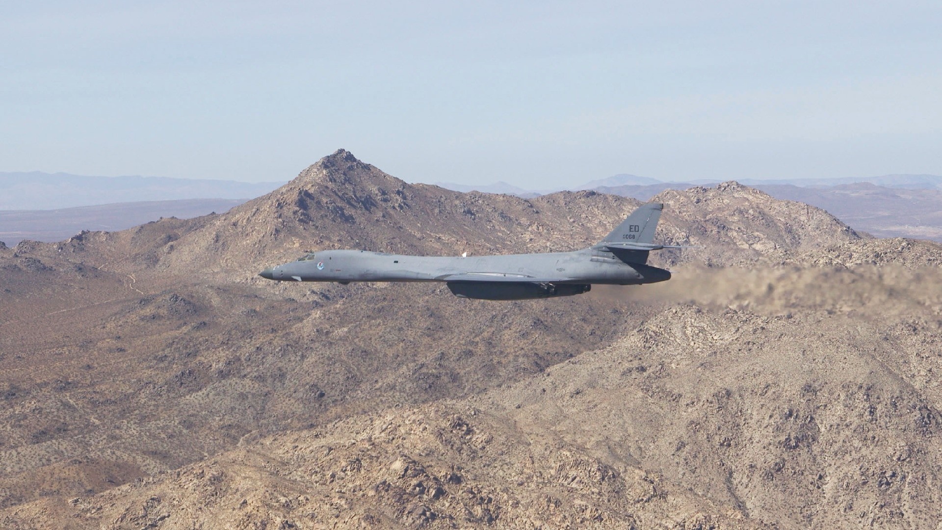 Rockwell B-1 Lancer bomber flying over mountains HD Wallpaper