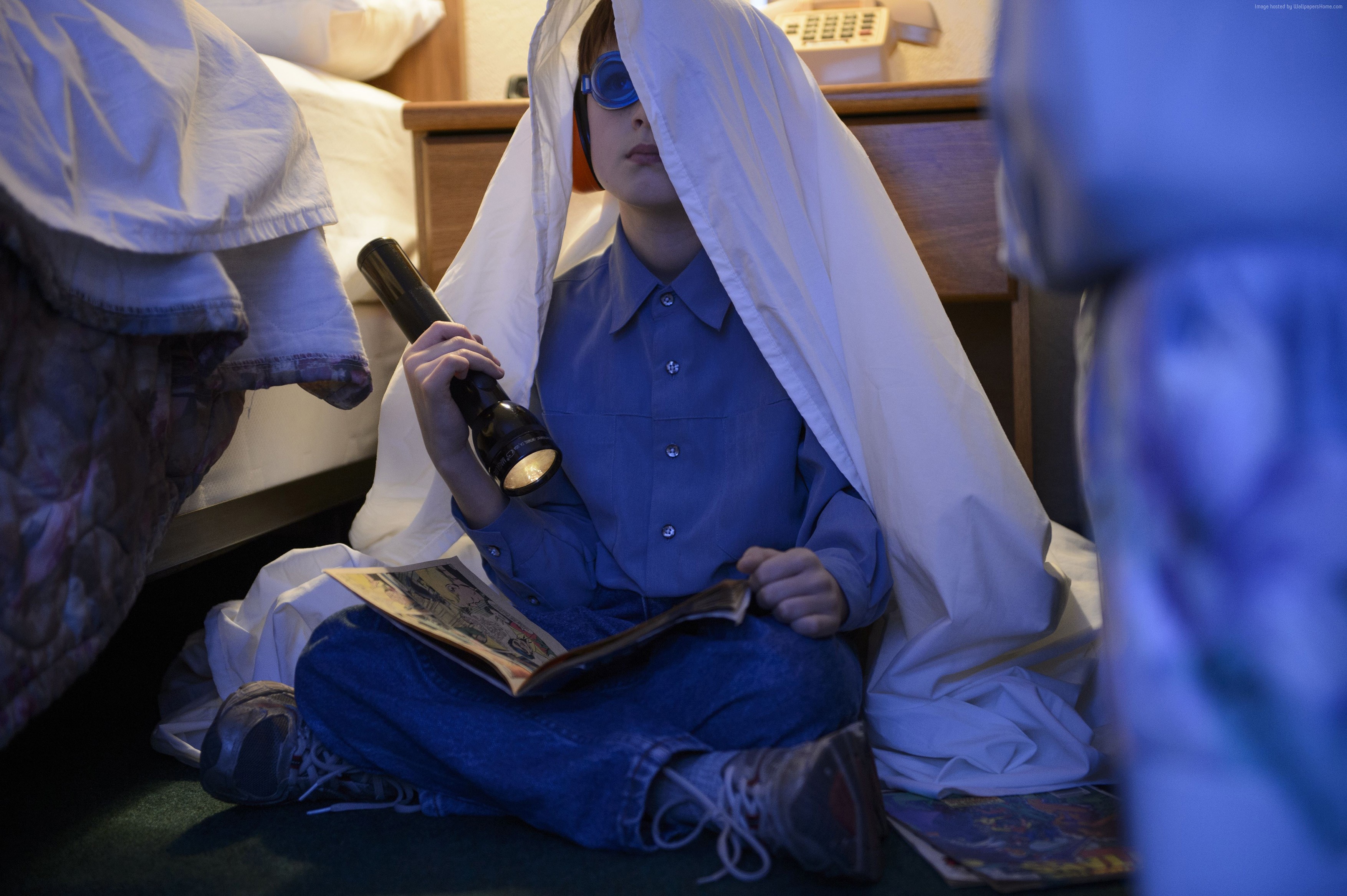 Boy with flashlight reading under blanket HD Wallpaper