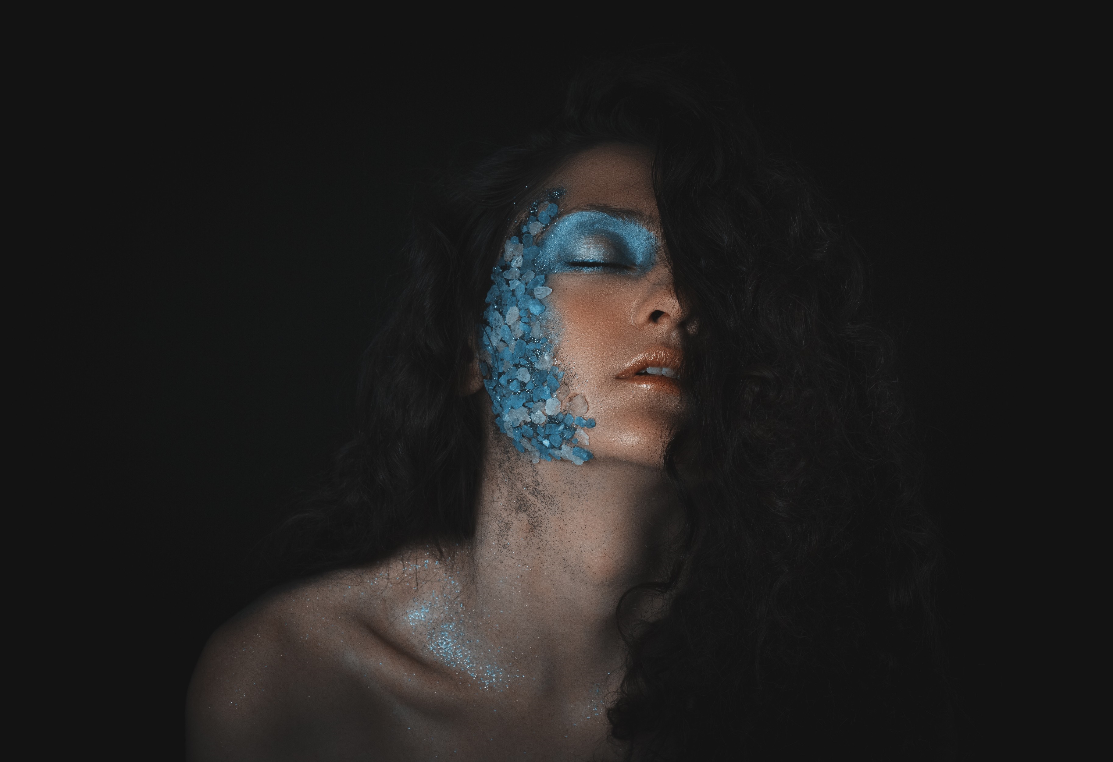 Woman with blue face paint and glitter HD Wallpaper
