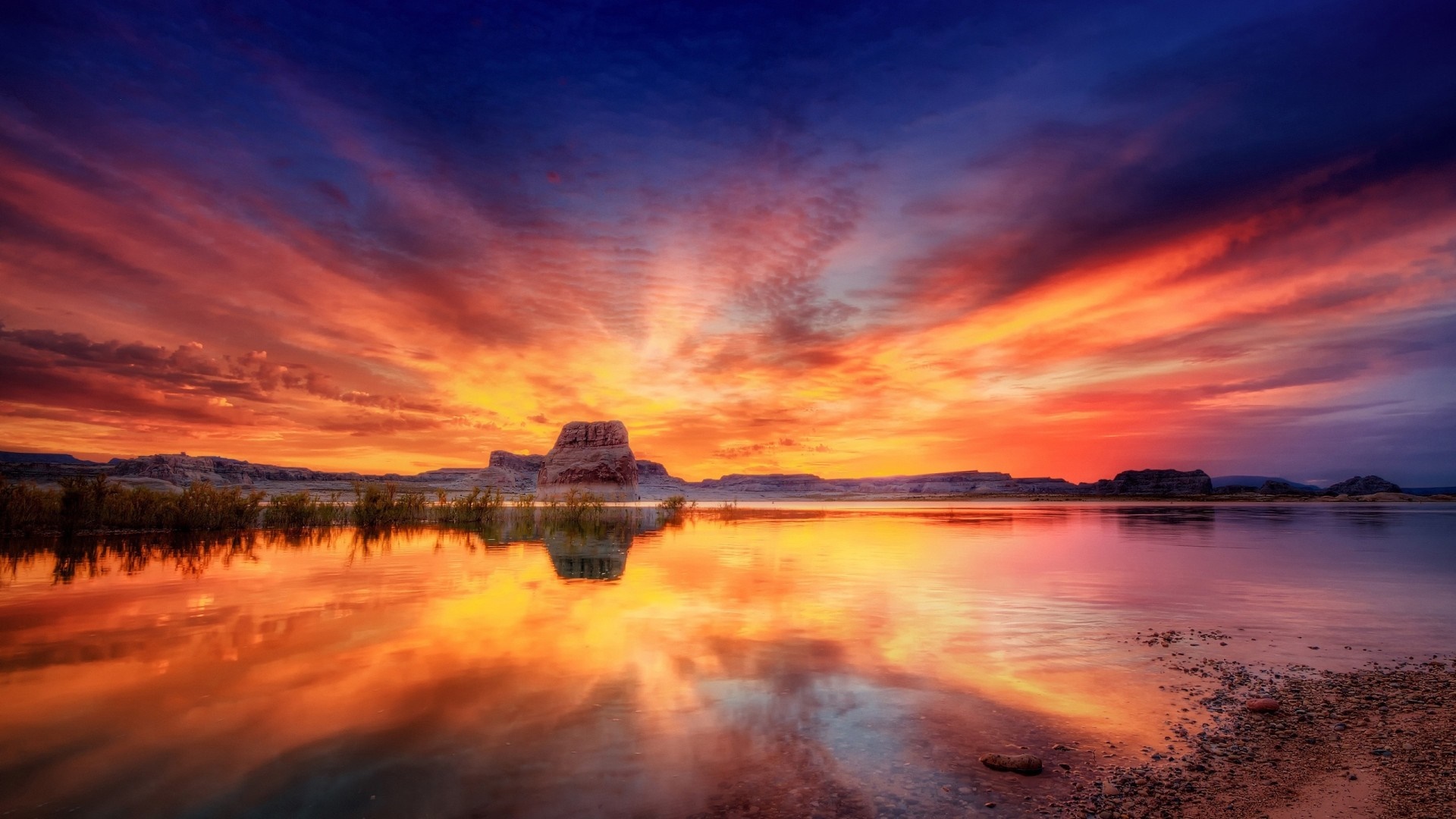 Sunset over a lake with rock formations and colorful sky HD Wallpaper