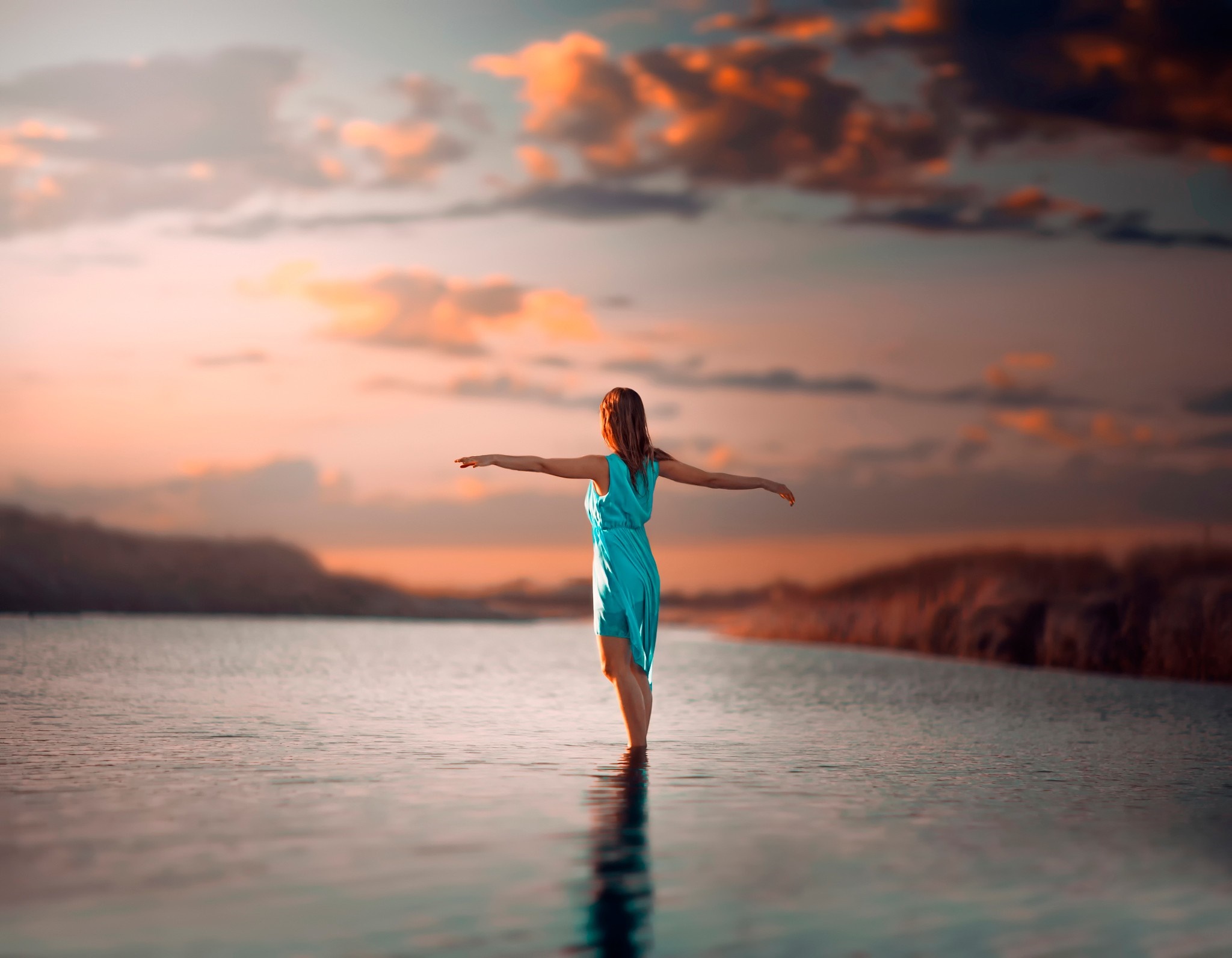 Woman in blue dress standing in water at sunset HD Wallpaper