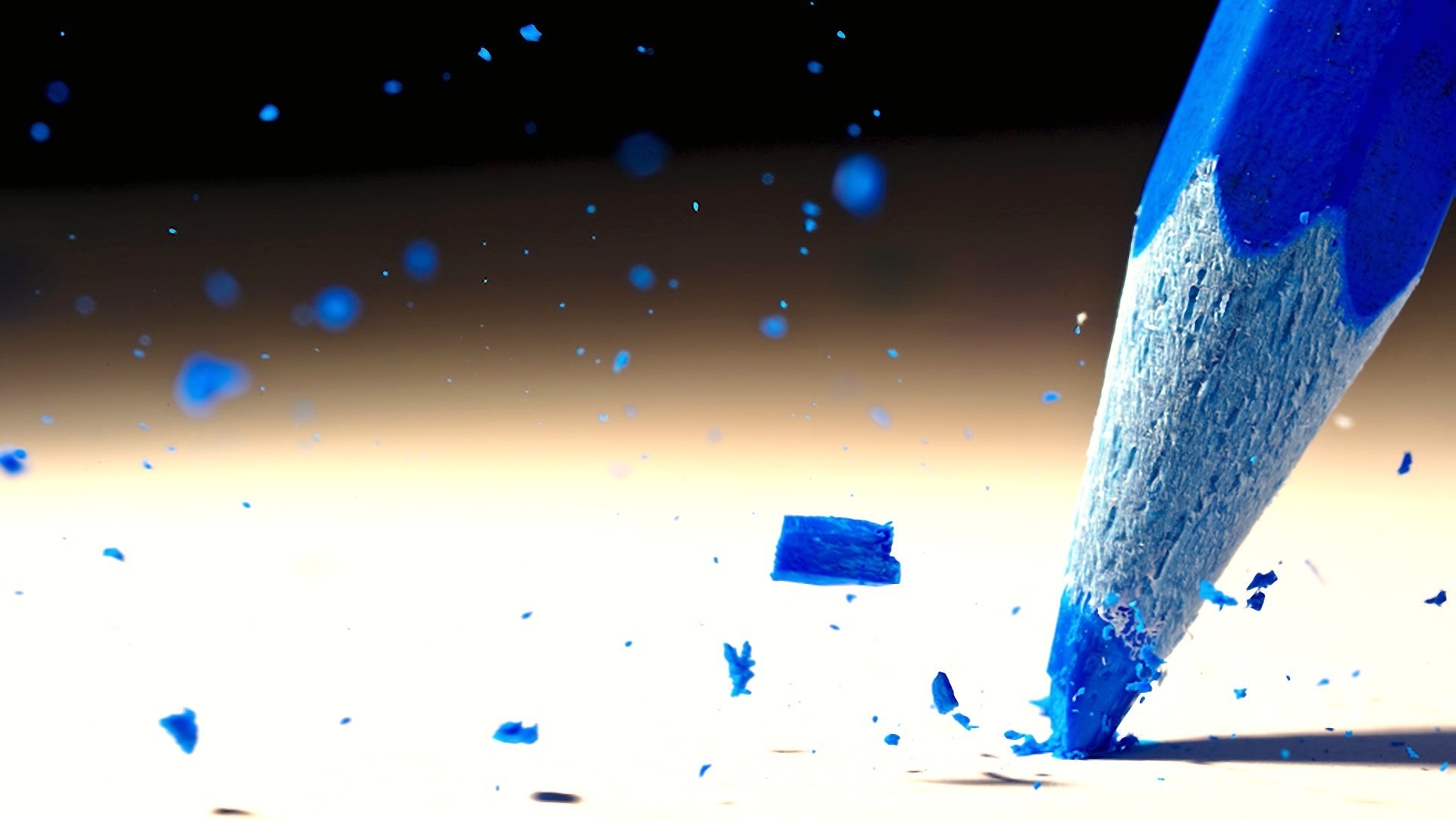Blue pencil breaking on a white surface with blue fragments flying HD Wallpaper